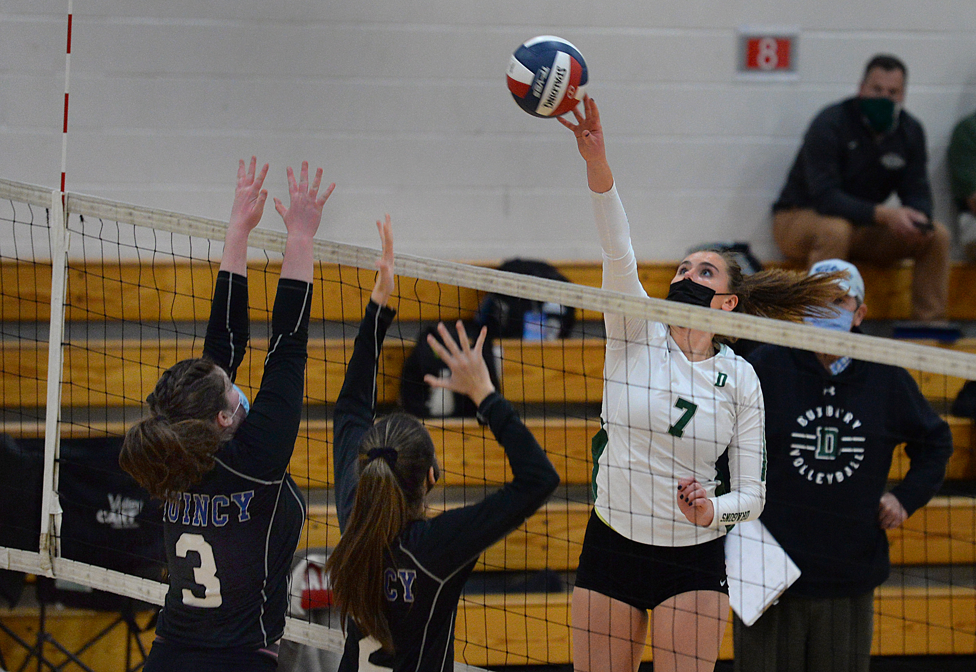 Duxbury's Sarah Leonard extends her finger tips for a tap over the net as Quincy's Ashley Grehan (left) and Bridget Hoare defend the play Friday night.