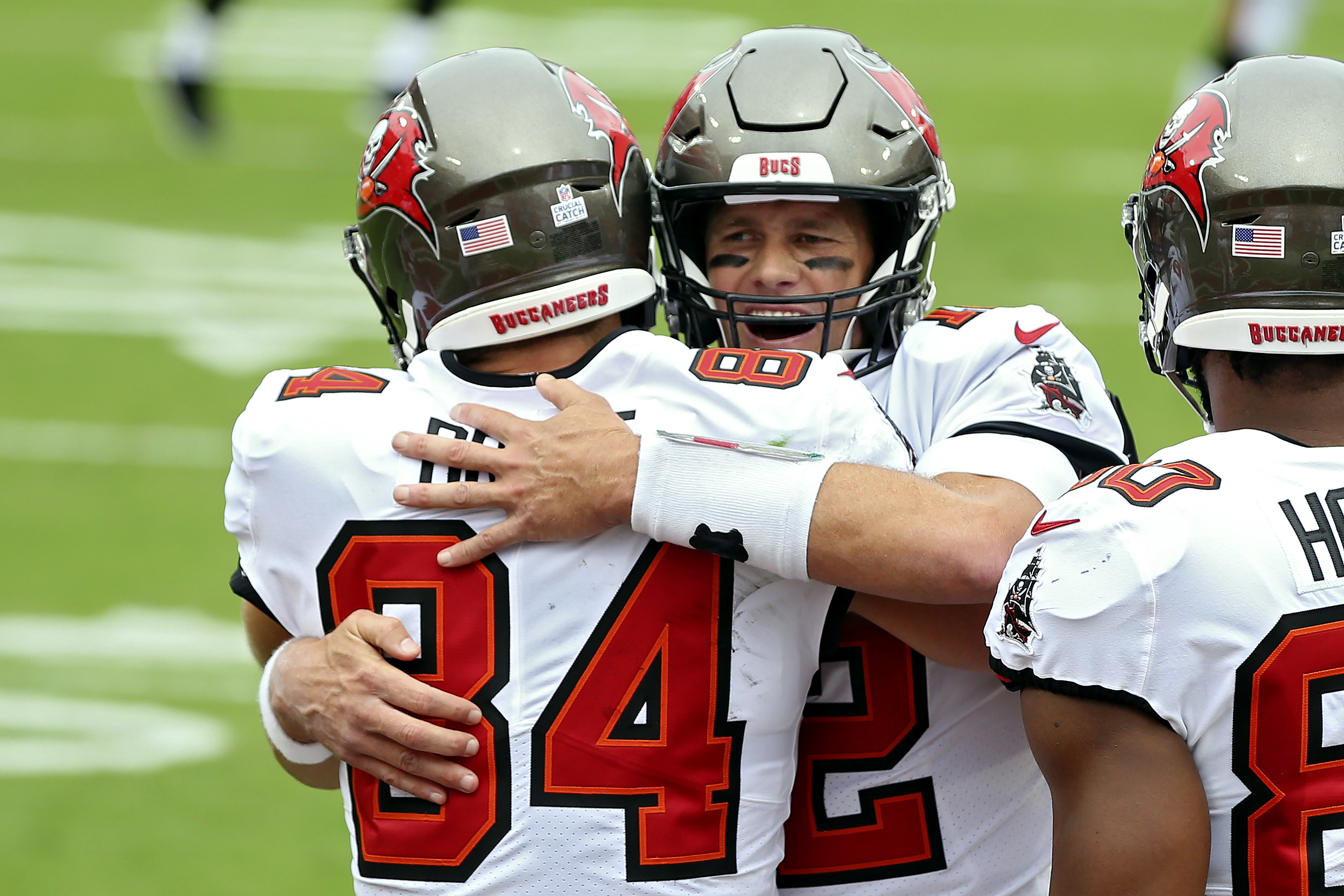 Tampa Bay quarterback Tom Brady hugs tight end Cameron Brate after Brate caught a touchdown pass from Brady during the first half of Sunday's game.