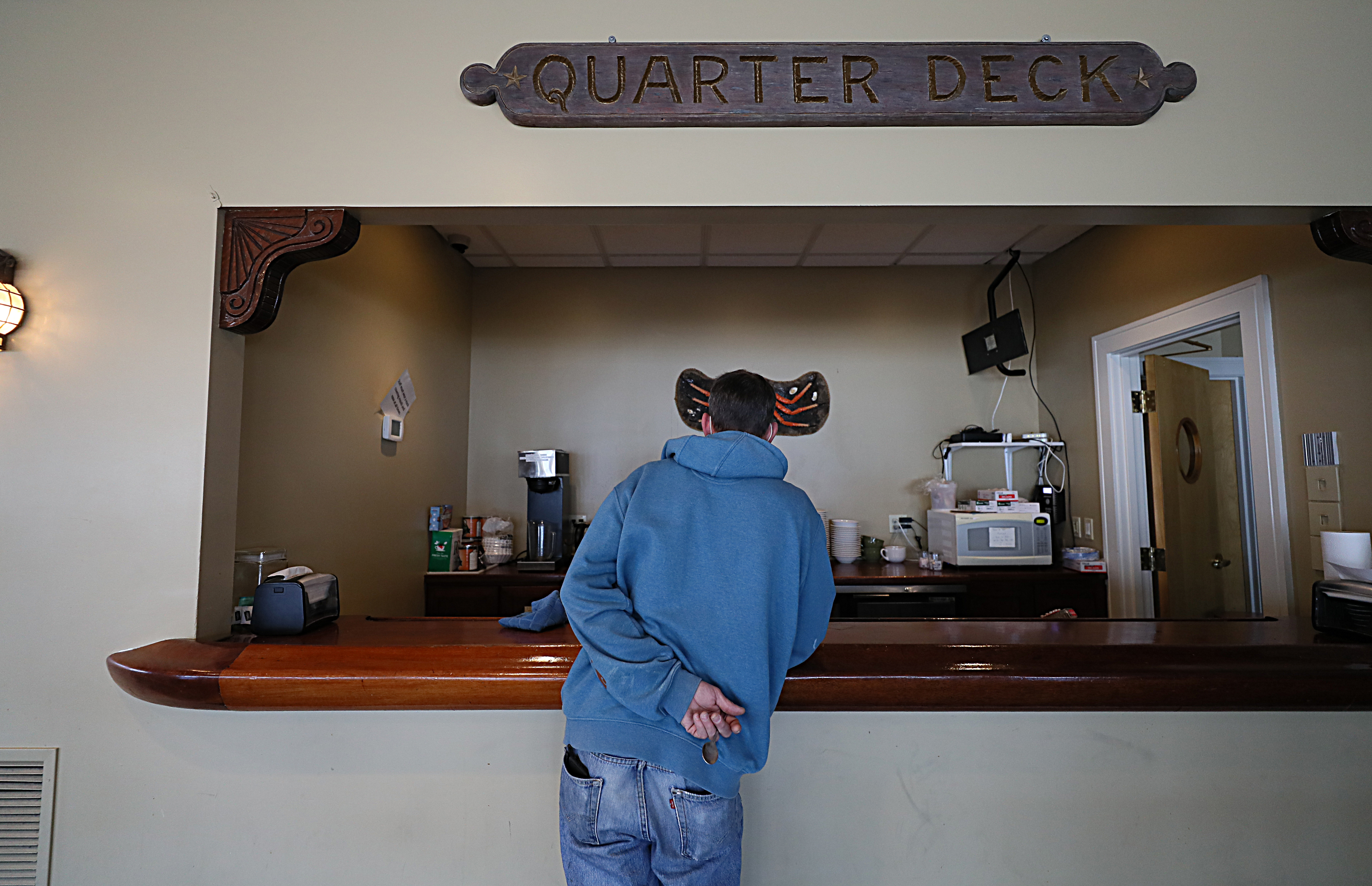 A guest of the relocated Grace Center gets a hot drink from what is normally the bar at the Gloucester House restaurant.