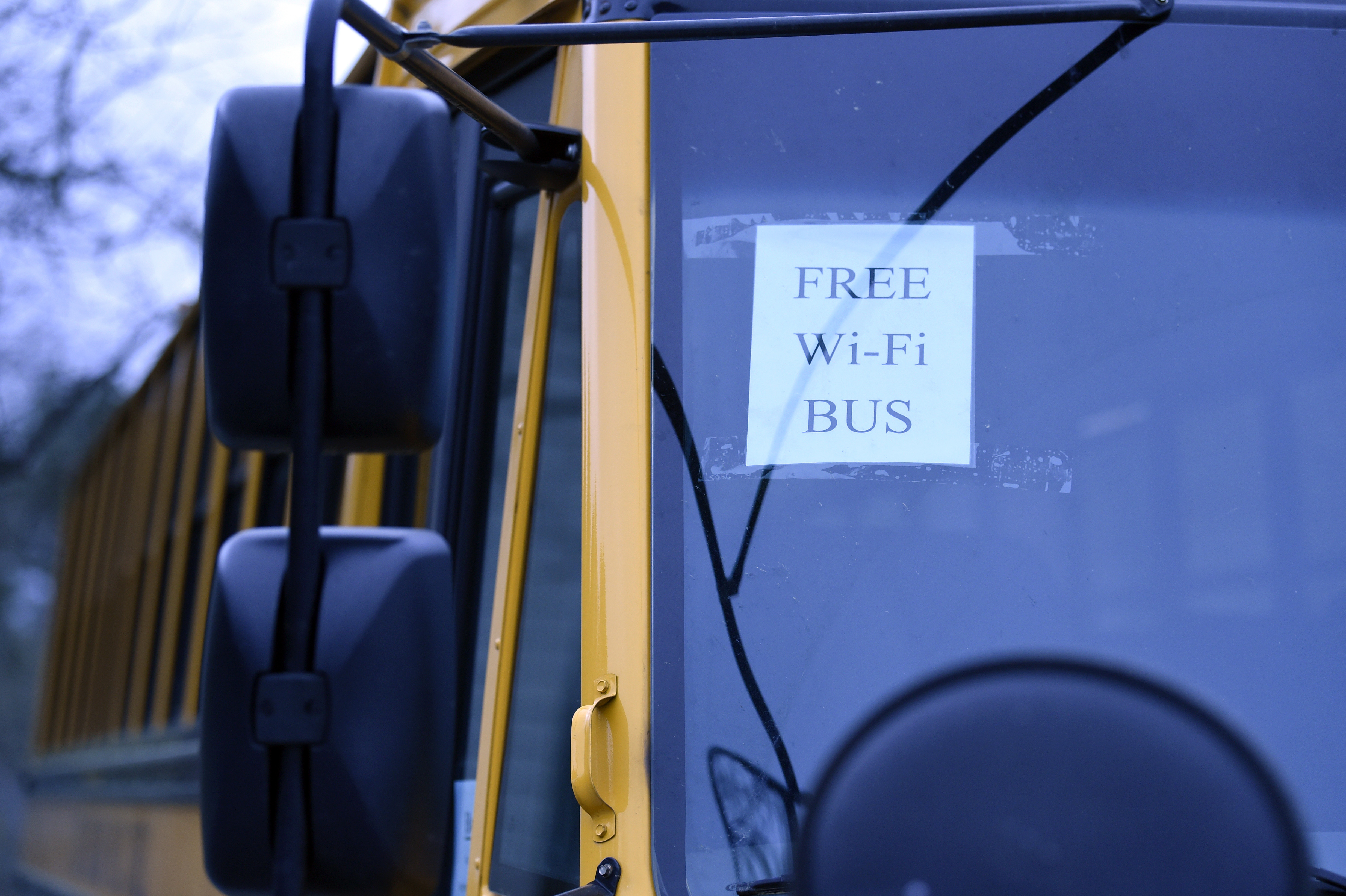 A Wi-Fi-enabled school bus, seen at an apartment complex in Winnsboro, S.C. in March 2020, is one of many sent to rural and lower-income areas around South Carolina to help students with distance learning during the coronavirus outbreak. With routers mounted inside, the buses broadcast enough bandwidth in an area the size of a small parking area for parents to drive up and children to access the internet from inside their cars.