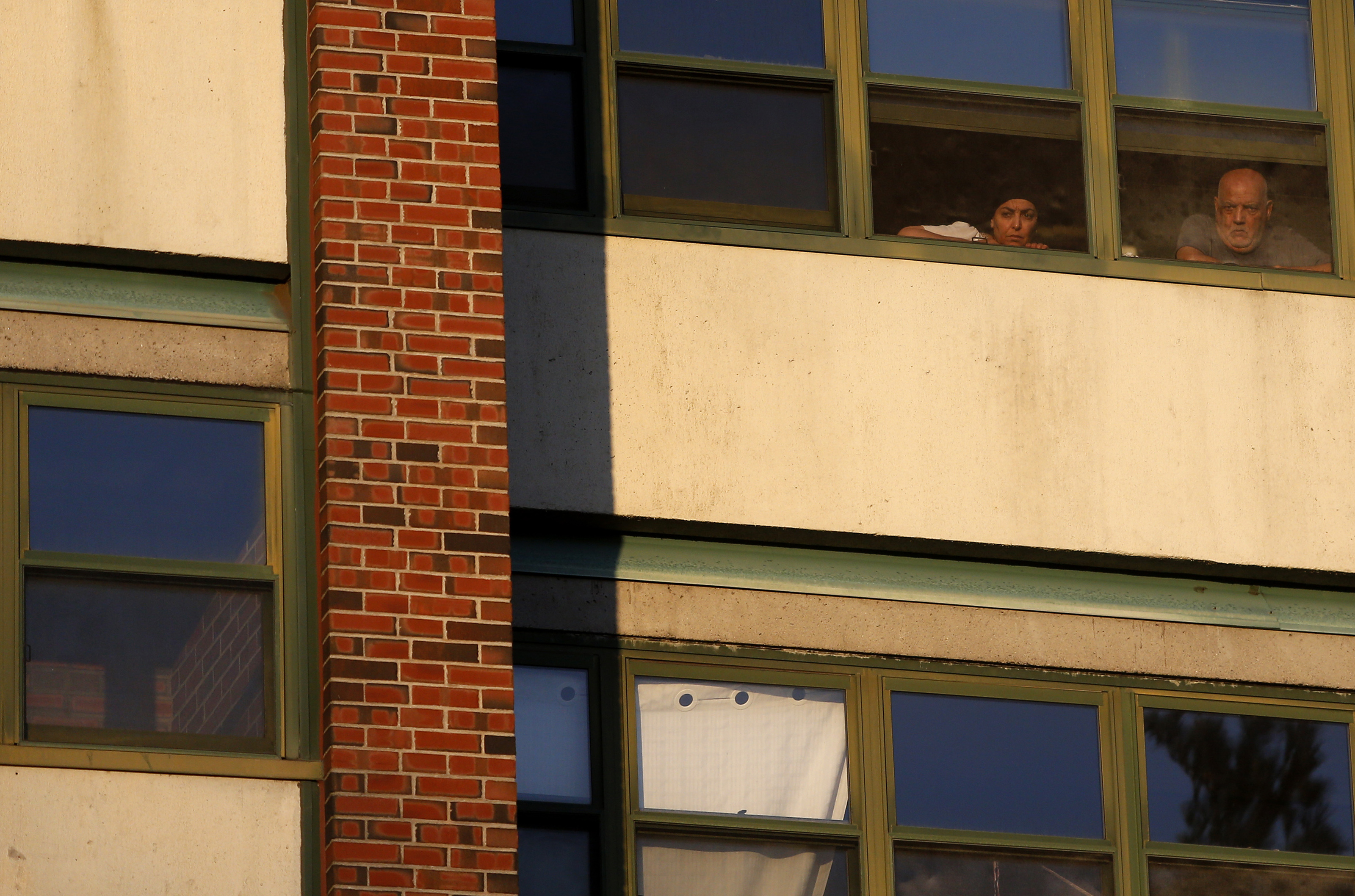 Monday, 6:48 p.m. People watched from their windows as a suspected coronavirus patient was taken out of their apartment building on a stretcher and loaded into the ambulance.