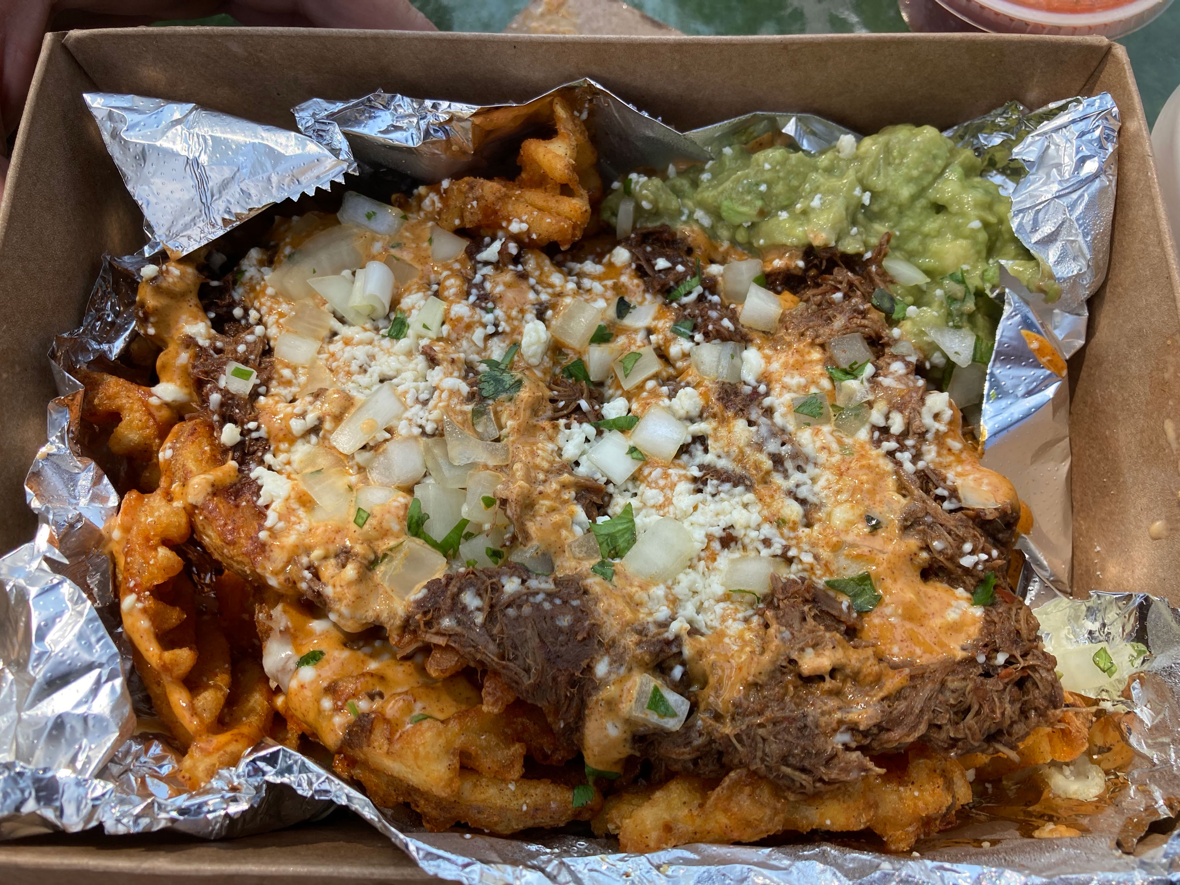 Birria fries at La Tacodilla in Dennis, with spiced beef, cheese, onion, cojita crema mayo, and guacamole.