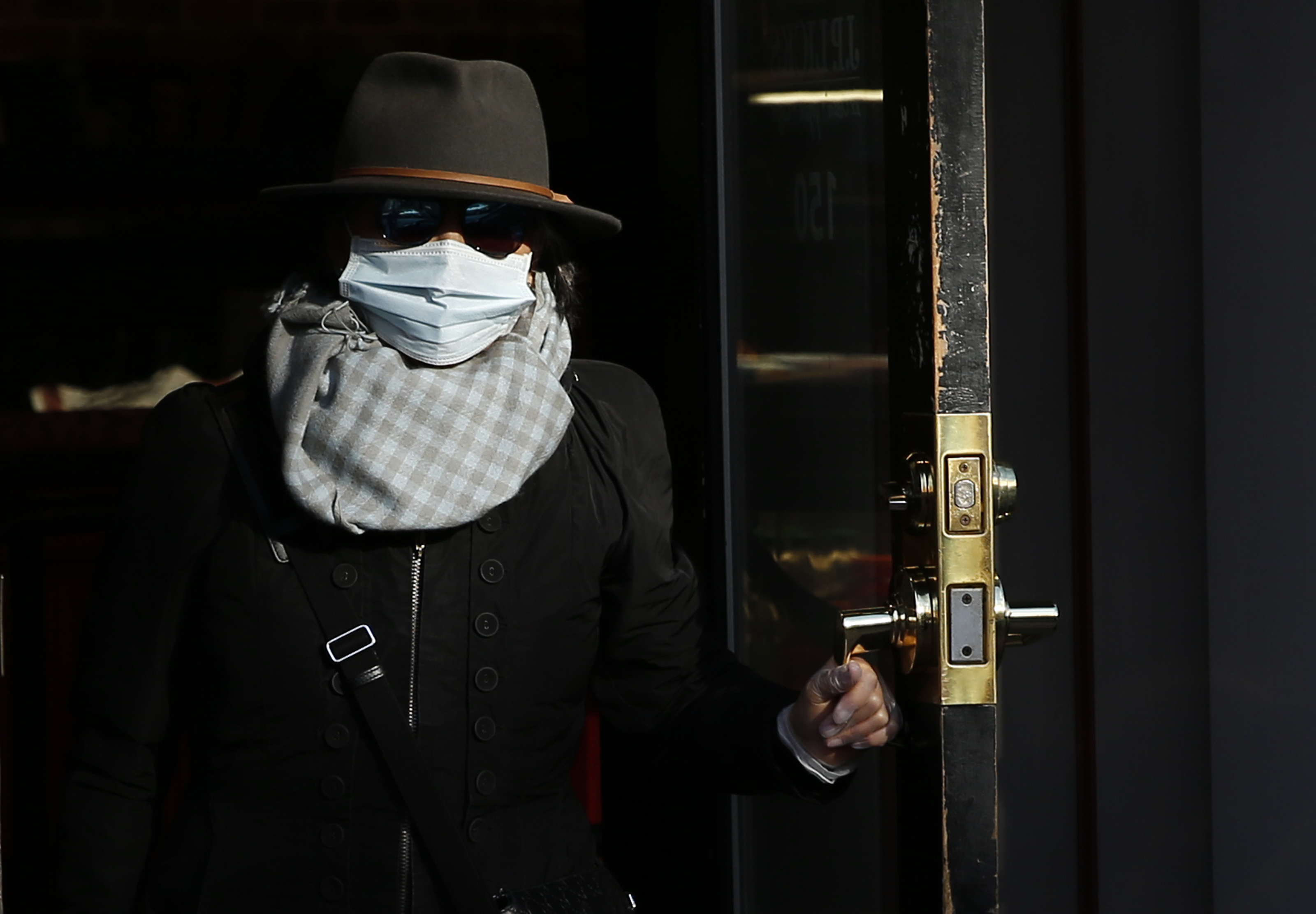 Boston, MA - 3/24/20 - A woman walked out of JP Licks on Beacon Hill after grabbing take out as the city empties out a day after Governor Charlie Baker issued a stay at home advisory for all non-essential workers as a way to reduce the spread of  coronavirus and flatten the COVID-19 curve.  (Jessica Rinaldi/Globe Staff)