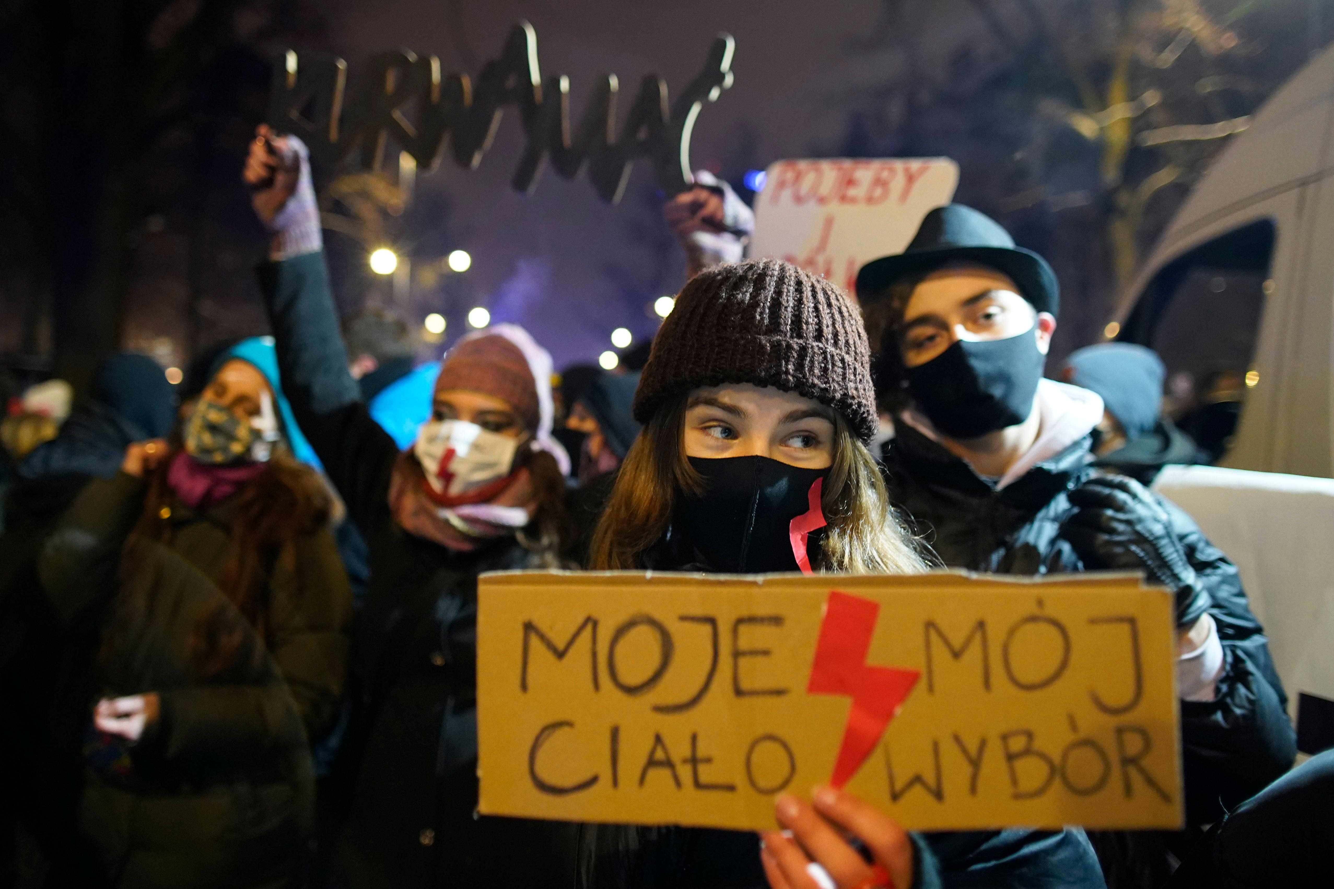 A demonstrator holds a sign reading 