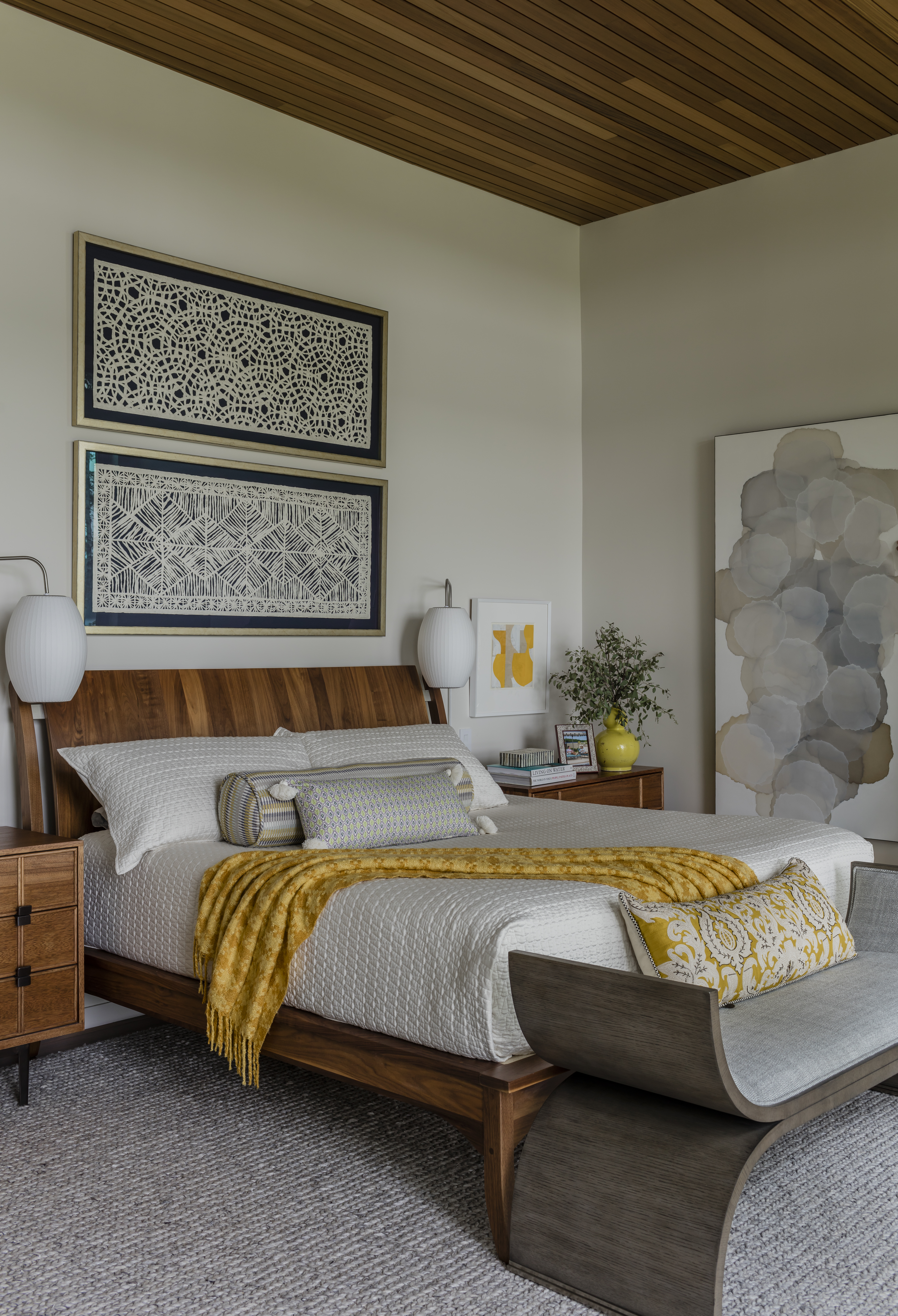 For the bedroom, Macumber channeled retreats in Bali. “The Pompanoosic Mills platform bed has the feel without getting kitschy,” she says. The woven paper artworks are a HomeGoods find, which the designer had custom mounted on navy silk and framed. The collage above the nightstand is by artist Karen Clarke.