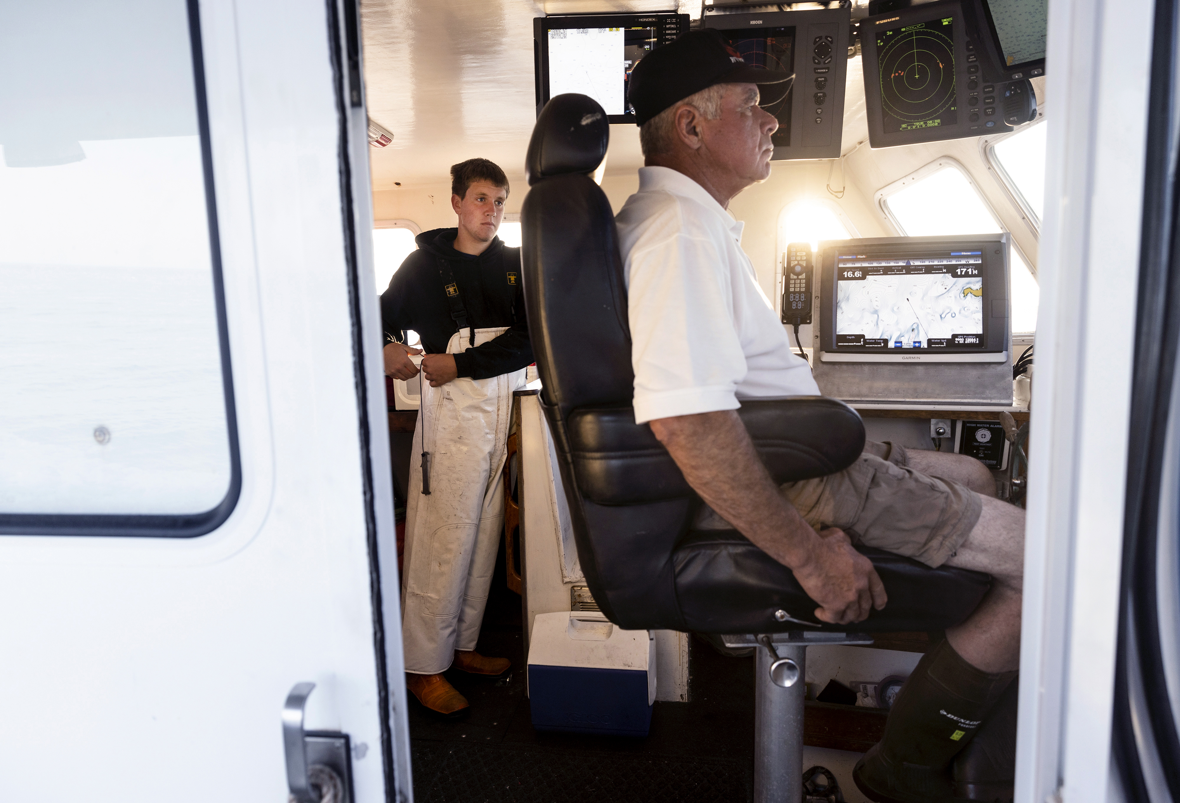 Tanner Lazaro (left) and Frankie Thompson in the cabin of Thompson’s boat, Obsession, as they steamed out to fish for lobster on July 24. Tanner has only ever wanted to work on the water and has found himself under the wing of Thompson, a veteran lobsterman. 