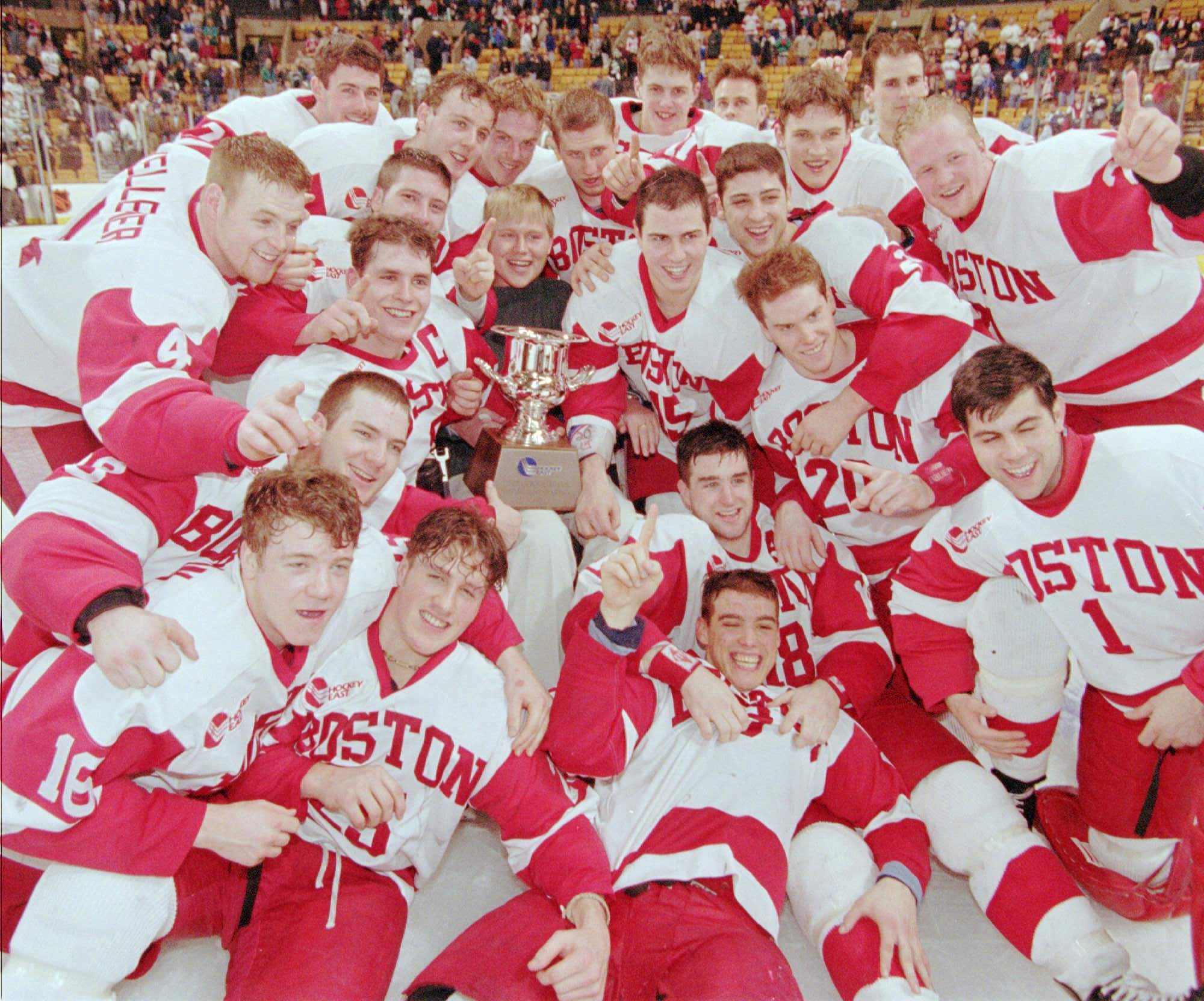 Boston University players celebrate around former player Travis Roy, center top, and the Hockey East Trophy after defeating New Hampshire 4-2 in the 1997 Hockey East Finals.