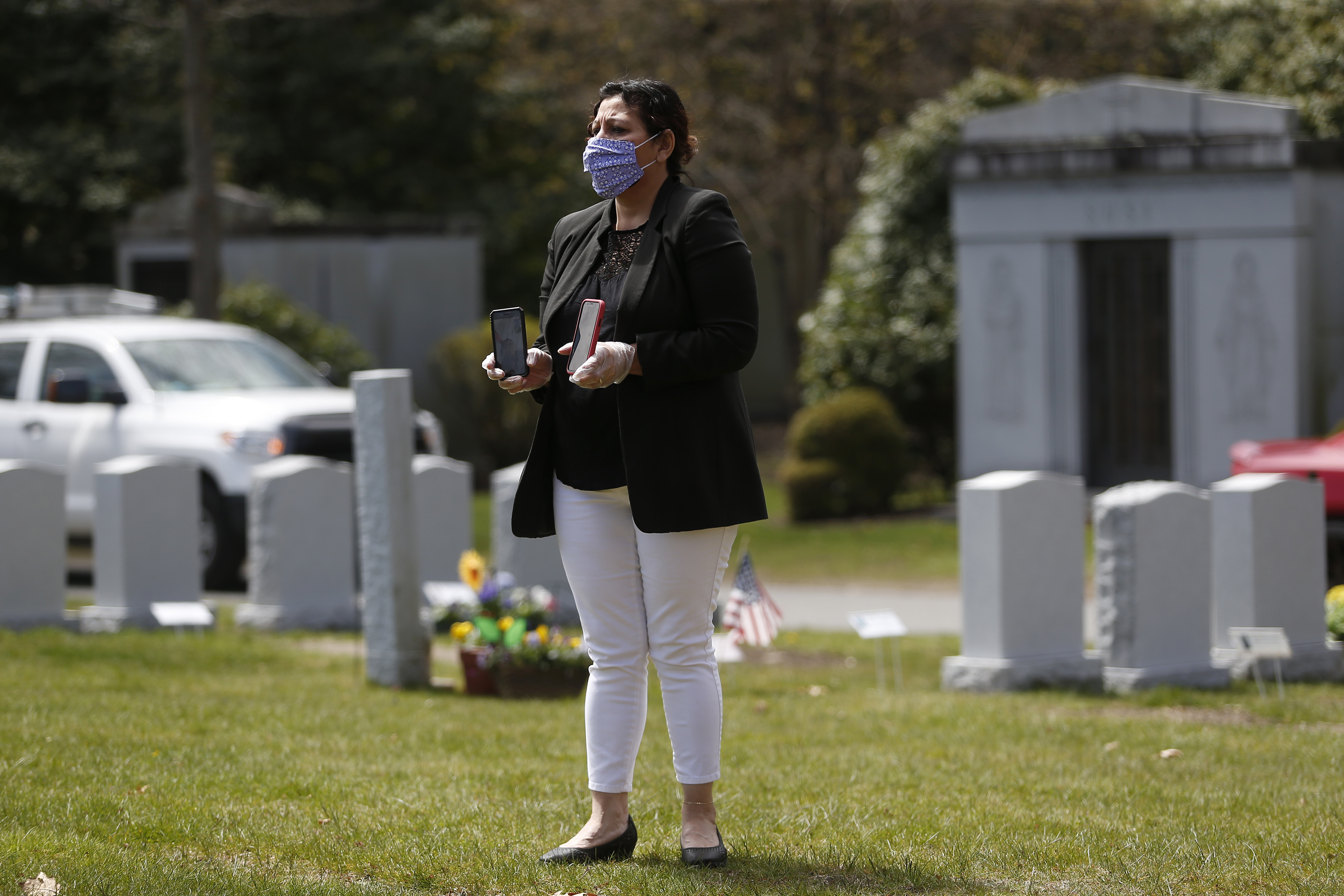 A mourner held out two phones to FaceTime Santos A. Rivas’s funeral for people who could not be there in person.