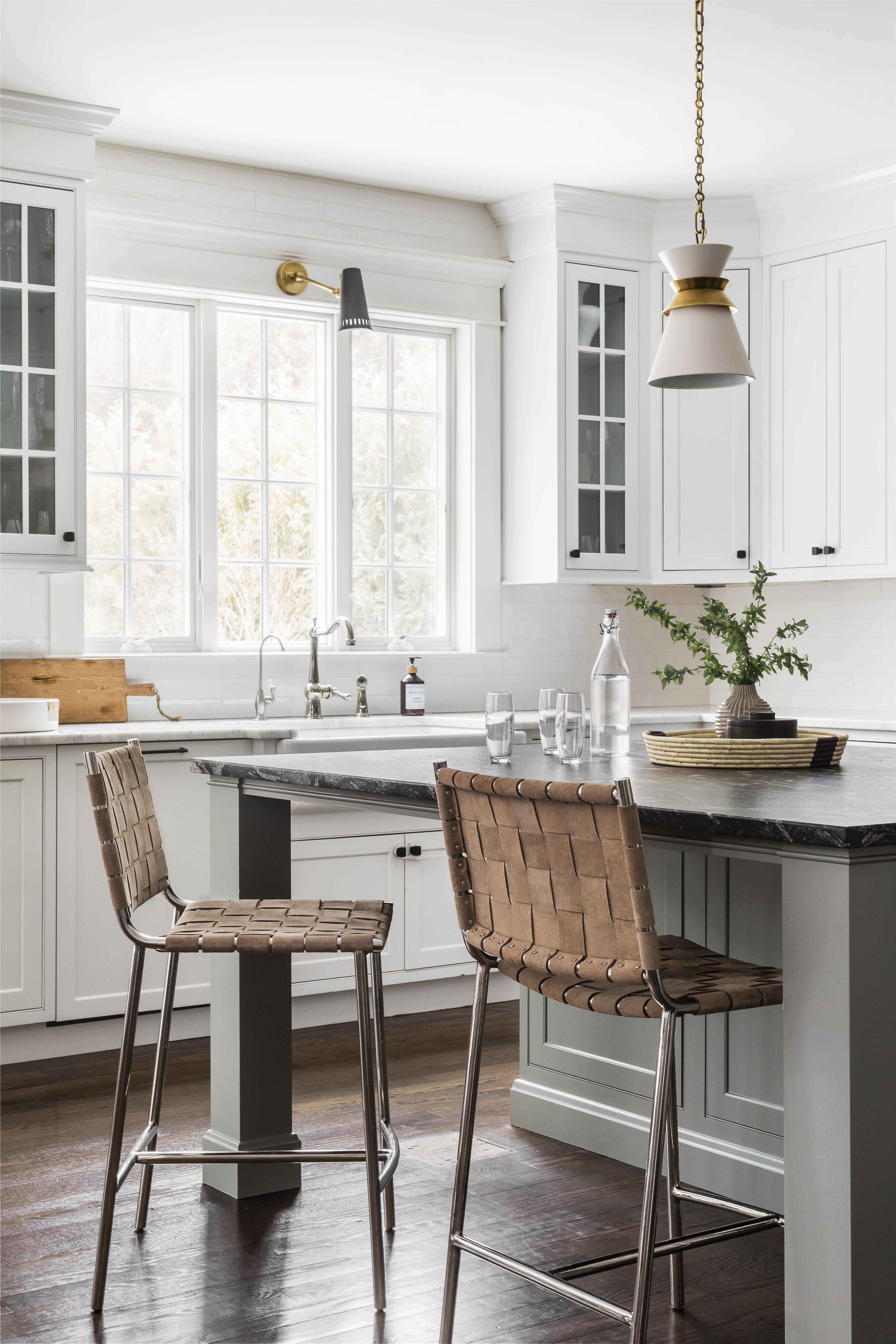 Brass accented lighting and matte black hardware up the style factor in the kitchen. Durable woven leather stools echo a leather ottoman in the living room.