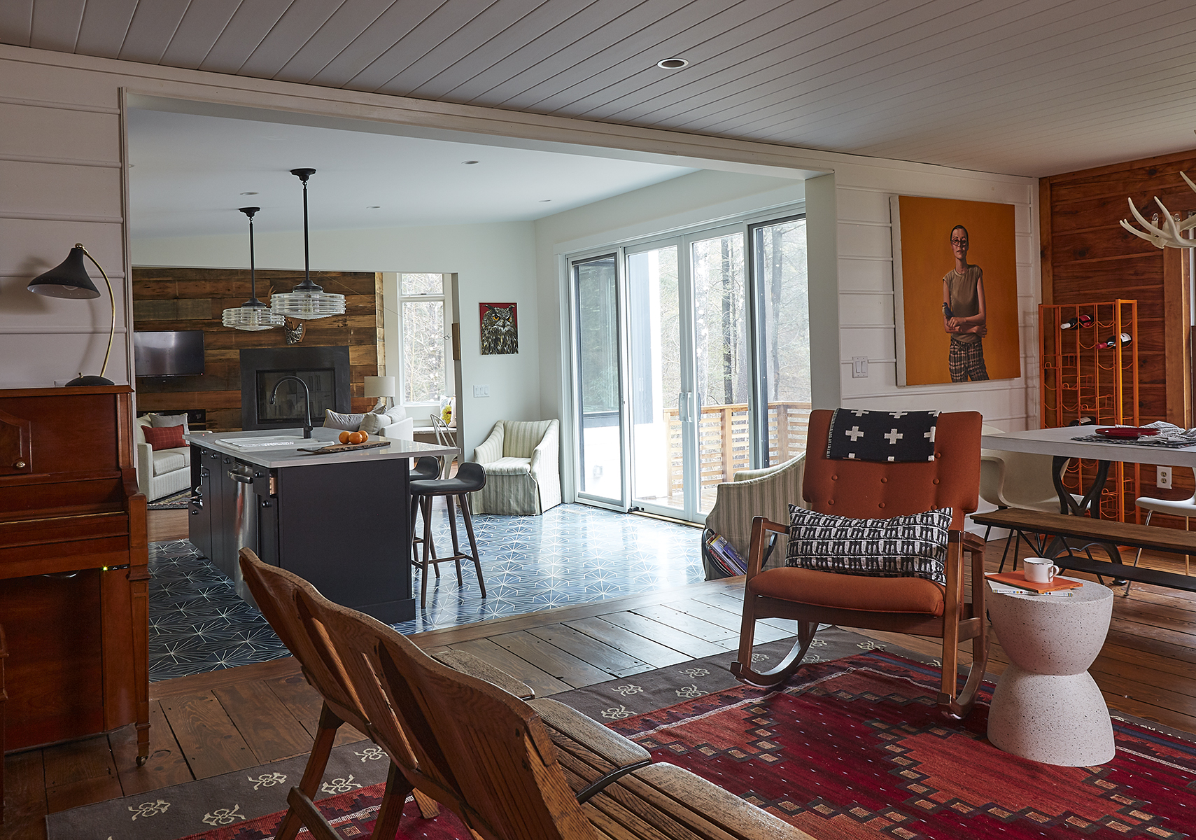 Sliders in the kitchen lead to a deck overlooking the river. The pendants are
from Schoolhouse, and the stools are from Article.