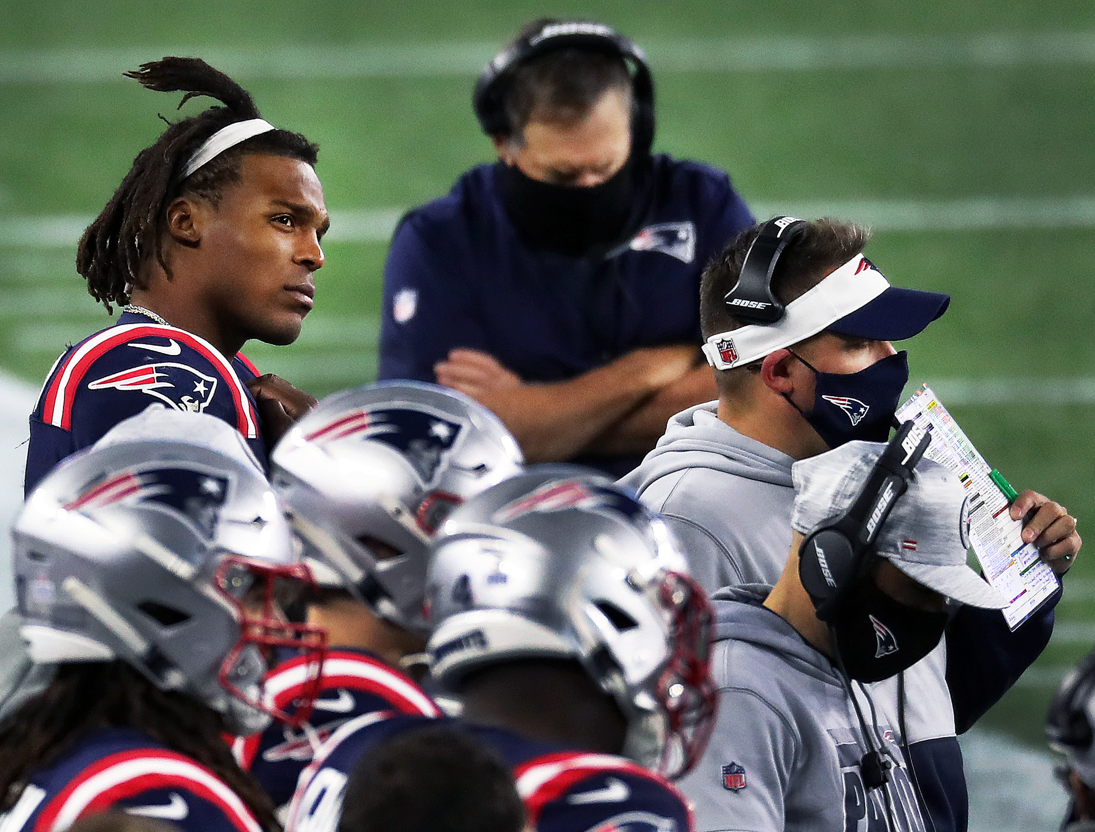 Cam Newton watches from the sideline after getting benched for the fourth quarter.