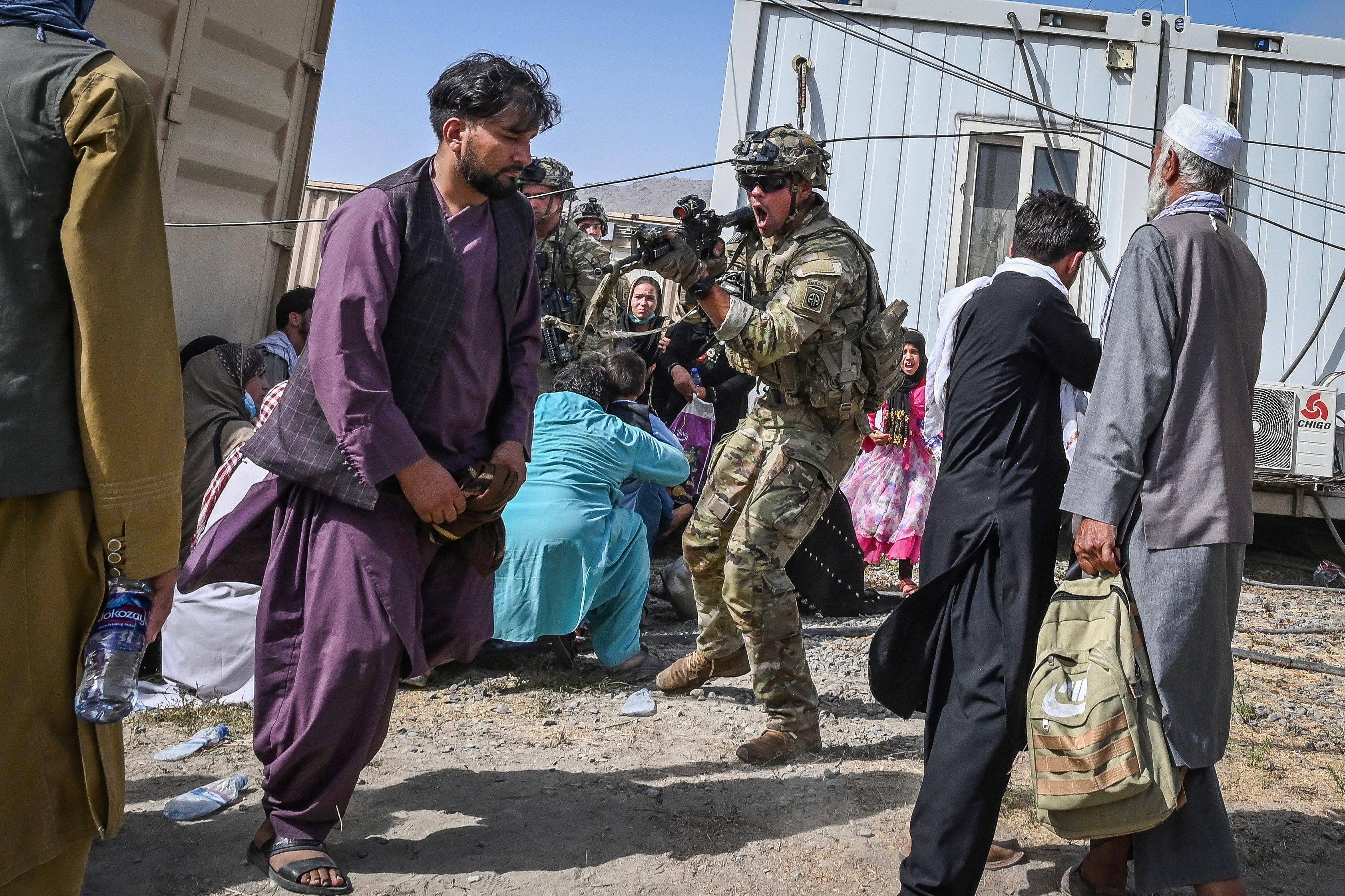 A US soldier pointed his gun towards an Afghan passenger at the Kabul airport in Kabul.