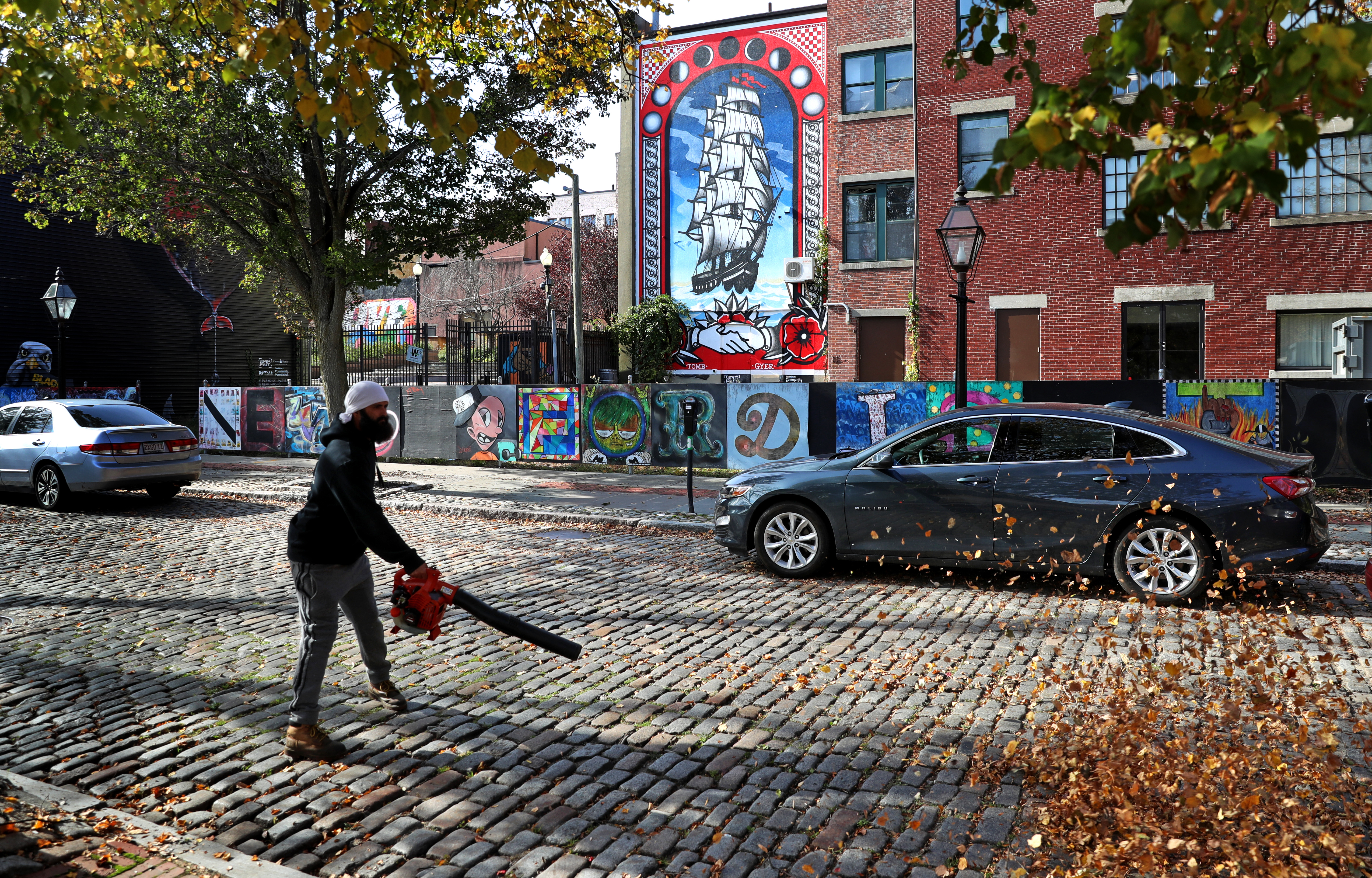 A landscaper blew leaves off cobblestones near the Fifty Fourth Regiment Massachusetts Volunteer Infantry Plaza in New Bedford.