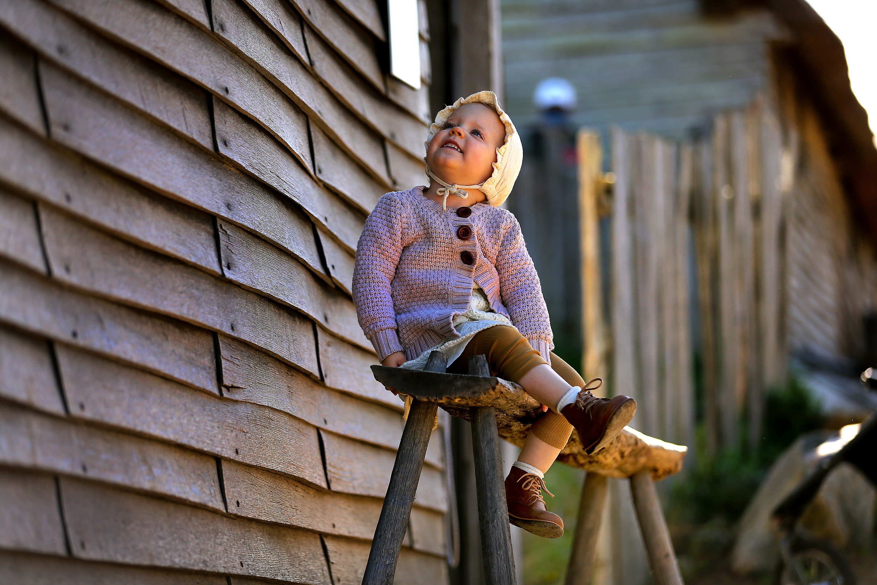 Despite the pandemic, Plimoth Patuxet Museum is welcoming visitors this Thanksgiving season. Sophie Amundson, 2, visiting from Rochester, Minn., sits on a bench outside one of the homes in Pilgrim Village.