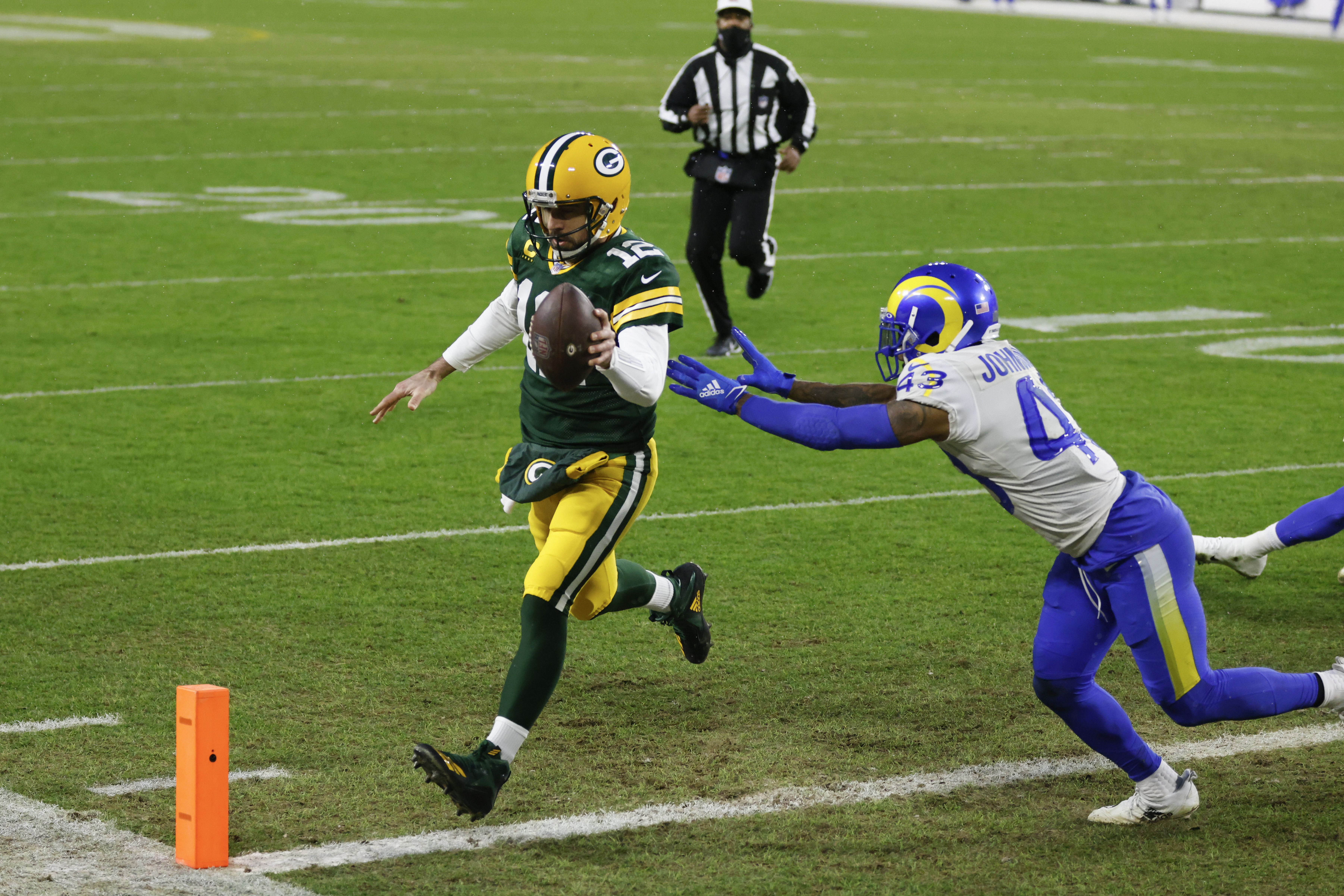 Packers quarterback Aaron Rodgers beats the Rams' John Johnson to the pylon on his 1-yard TD run in the first half.