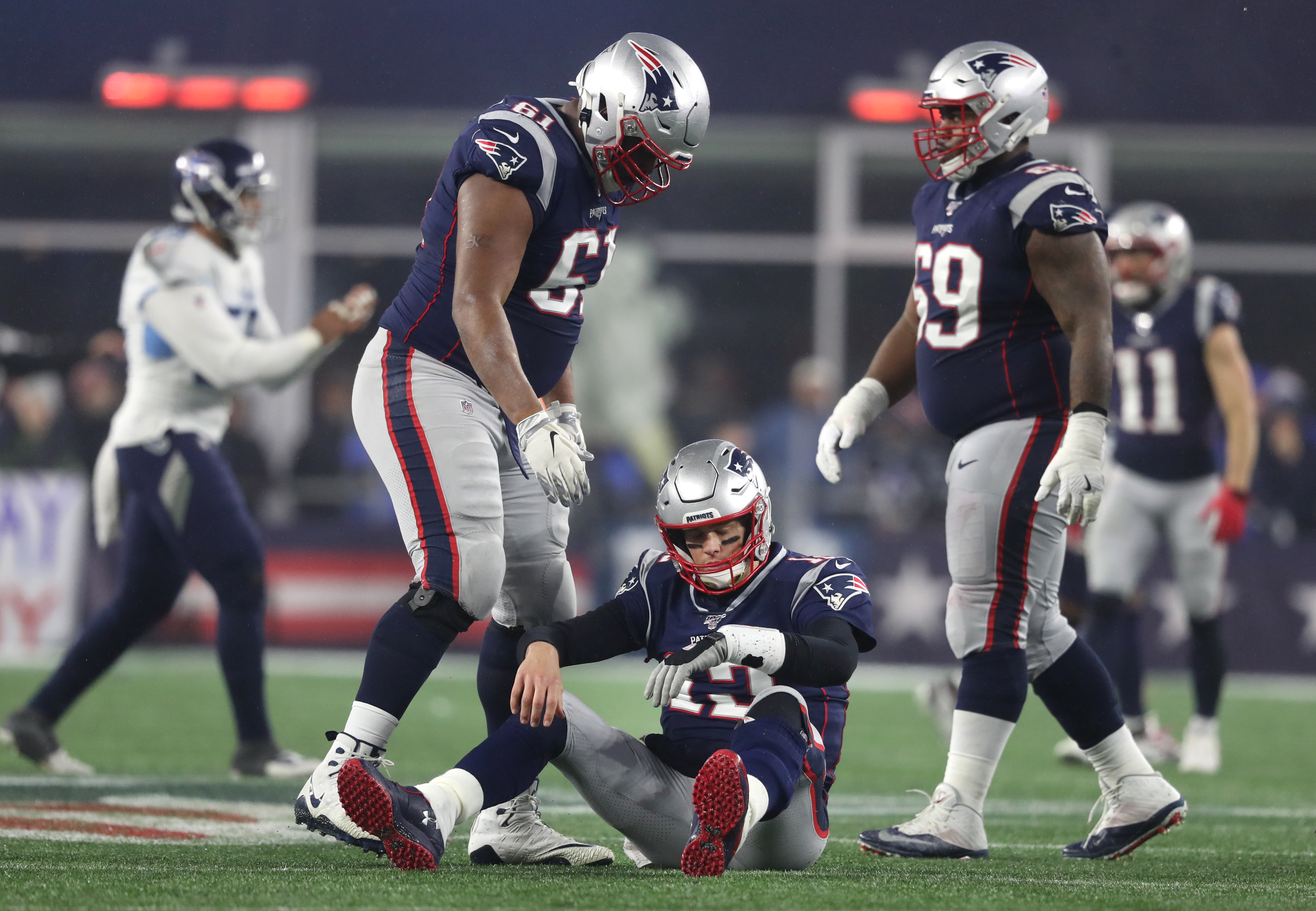 Tom Brady sat dejected on the Gillette Stadium turf after being knocked down in the fourth quarter of the AFC Wild Card game. The Titans topped the Patriots, 20-13.