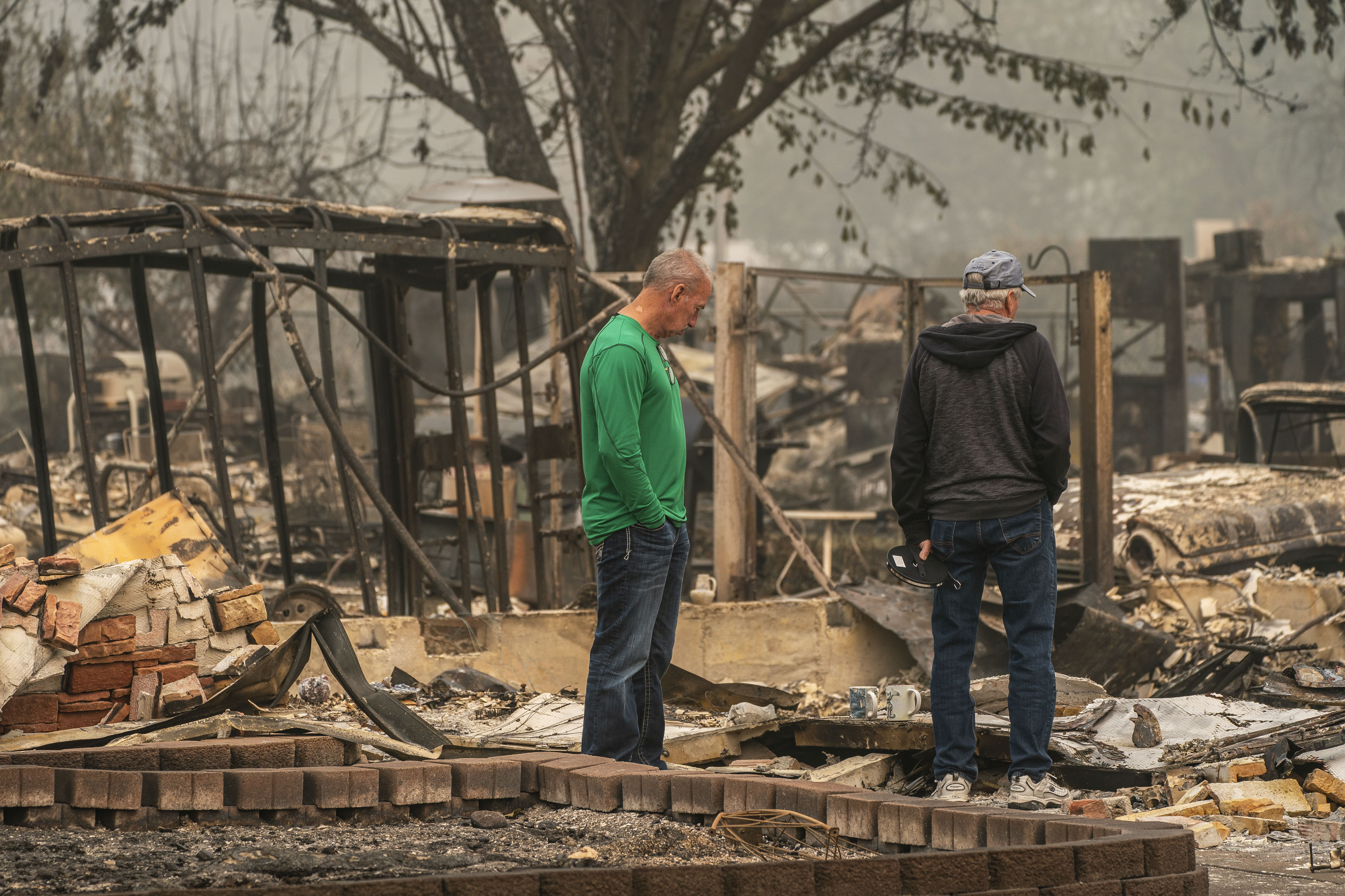 Homeowners survey their property in a neighborhood destroyed by wildfire in Talent, Oregon.
