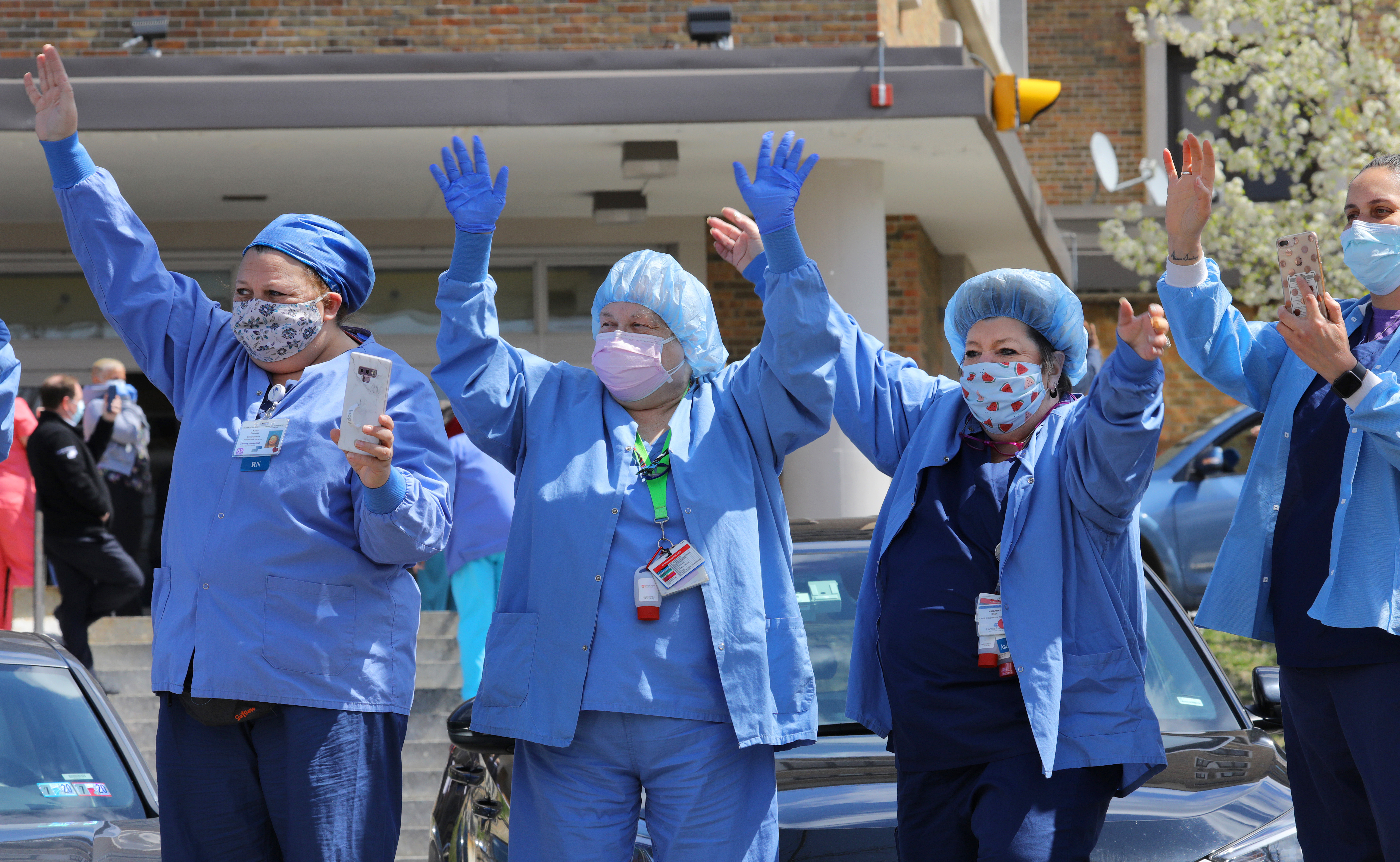 Boston, MA  4/16/2020  Carney Hospital staff watch a drive-by parade in their honor, which salutes their work during the COVID-19 pandemic.  The parade was organized by Boston City Councilor Frank Baker.  (Pat Greenhouse/Globe Staff)