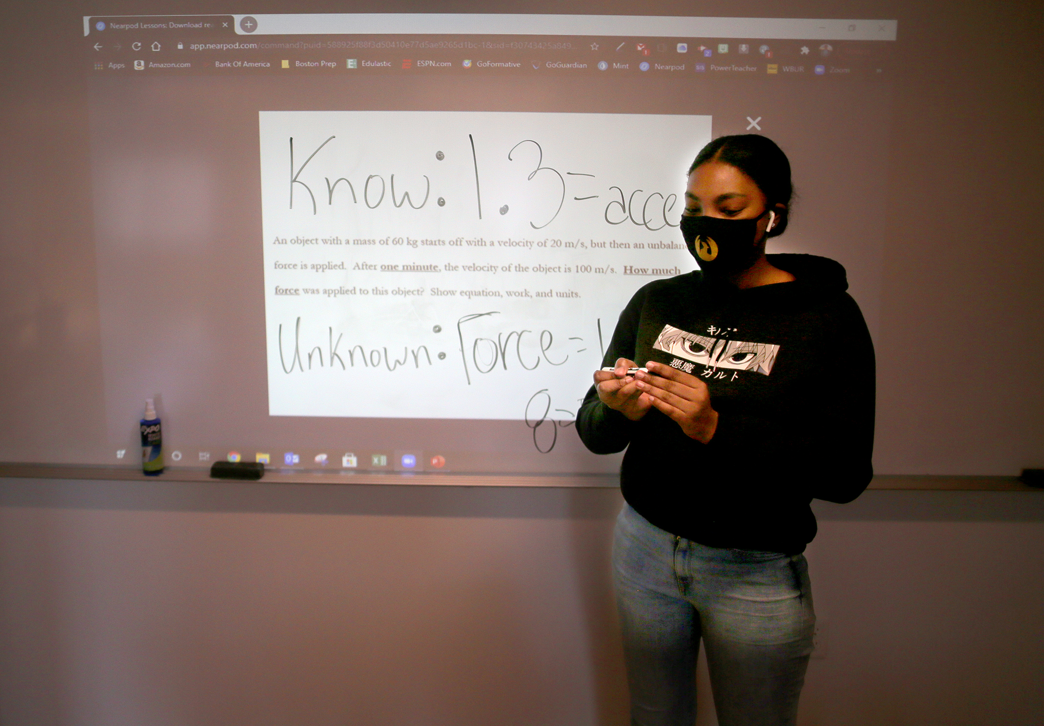 Student Kayla Jones writes on the board in class - and on Zoom for students still at home - in teacher William Geddes' 10th-grade physics class at Boston Prep.