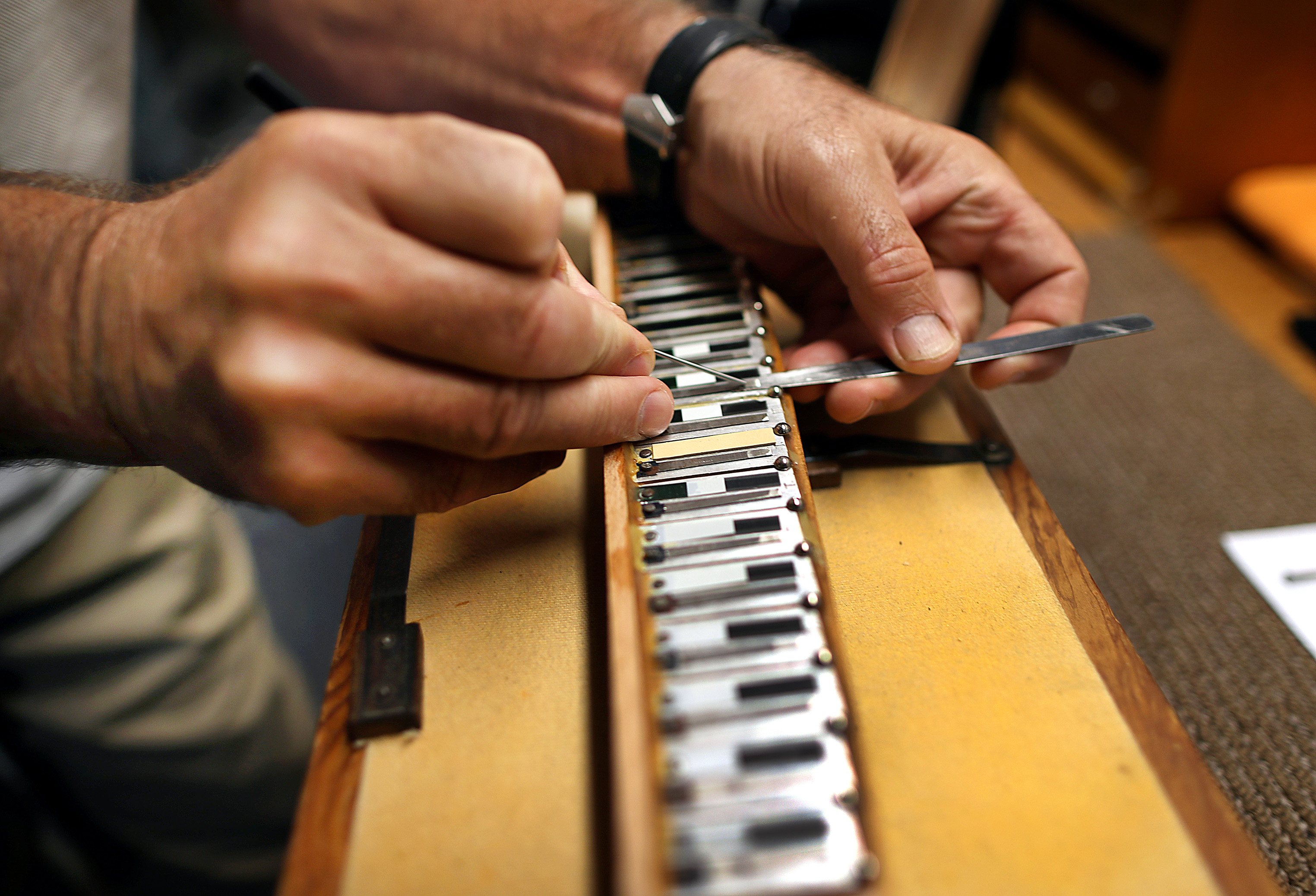 Paul Tagliamonte Jr. works to adjust the tune in a reed block.