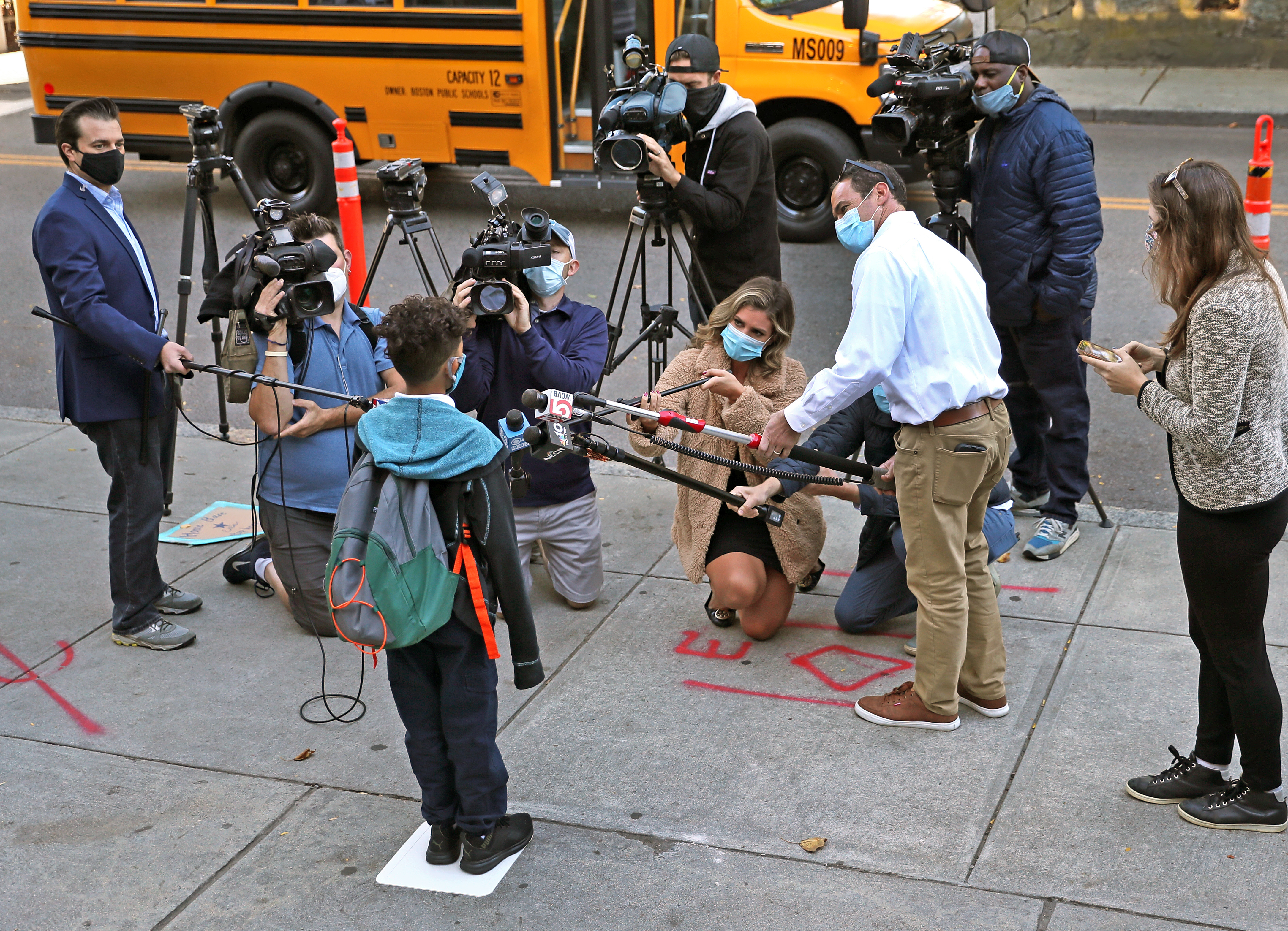 Edward Velazquez, a fifth grade student at the Ellis Elementary School in Roxbury, was greeted by the media on the front steps of the school for his first day back to the classroom.