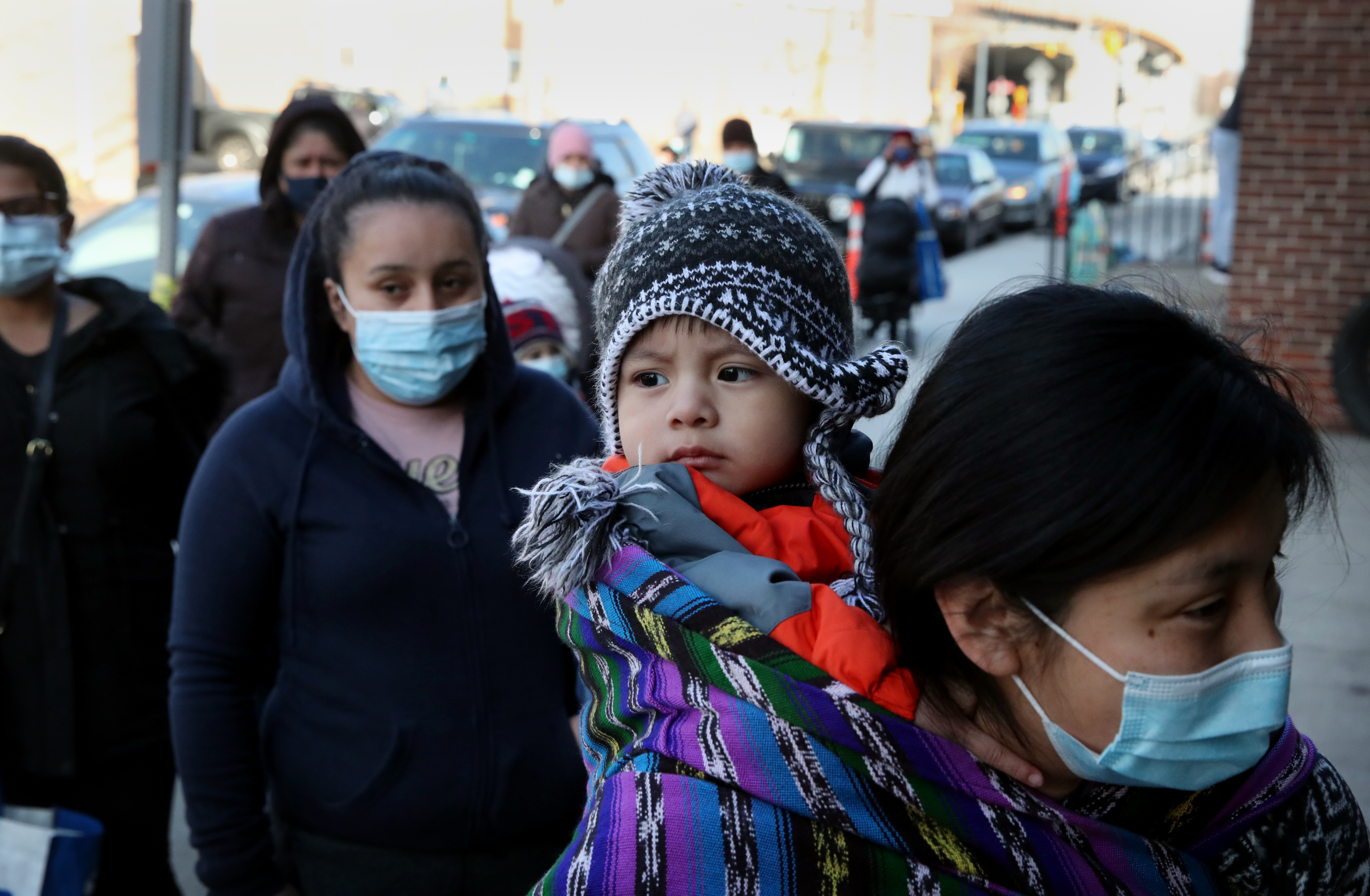 Lily Lopez carried her son Jonathan while picking up necessities at La Colaborativa in Chelsea.