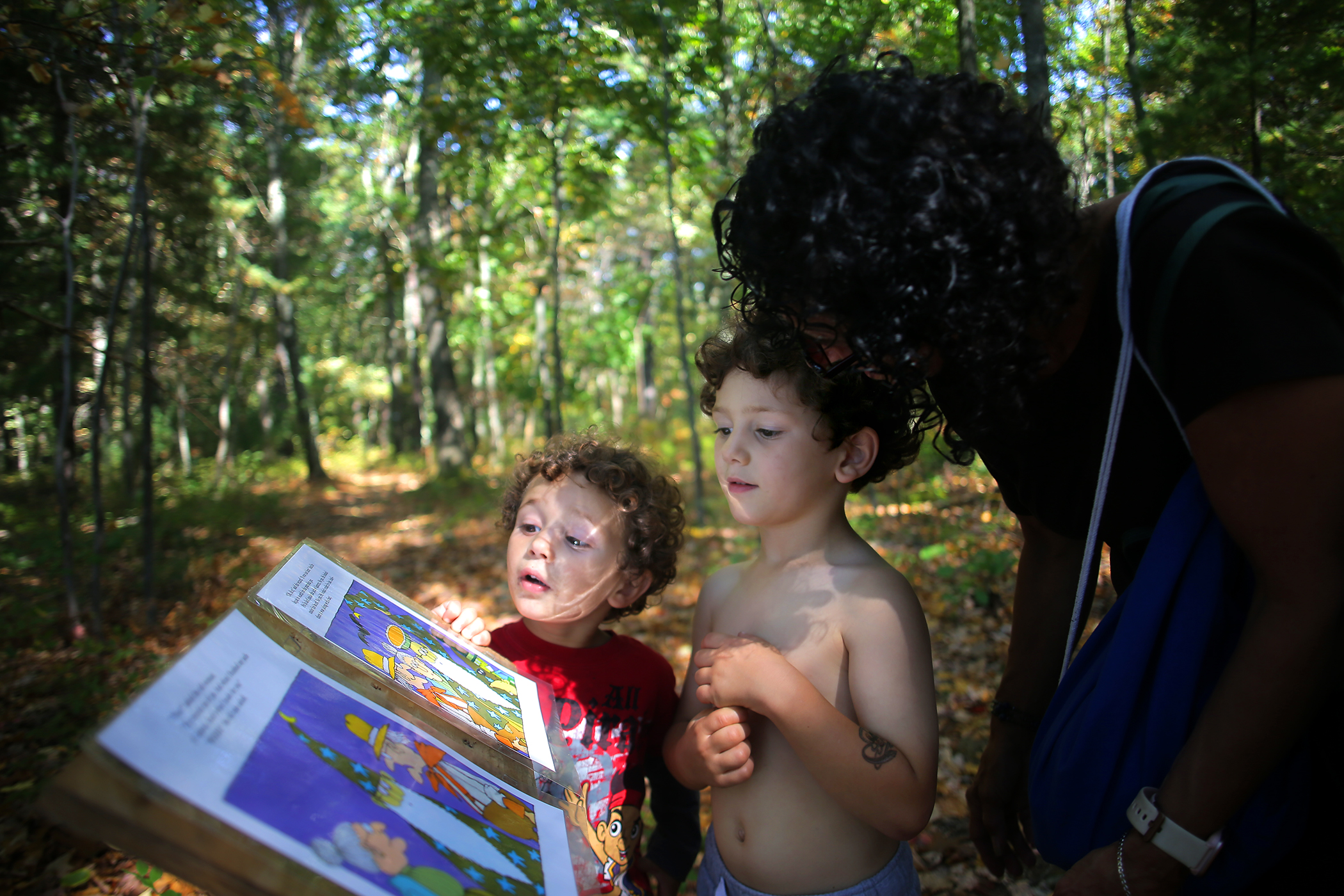 Linda Joyce helped her grandsons, Christopher Pittman, 4, and Calvin Pittman, 2, read on the StoryWalk.