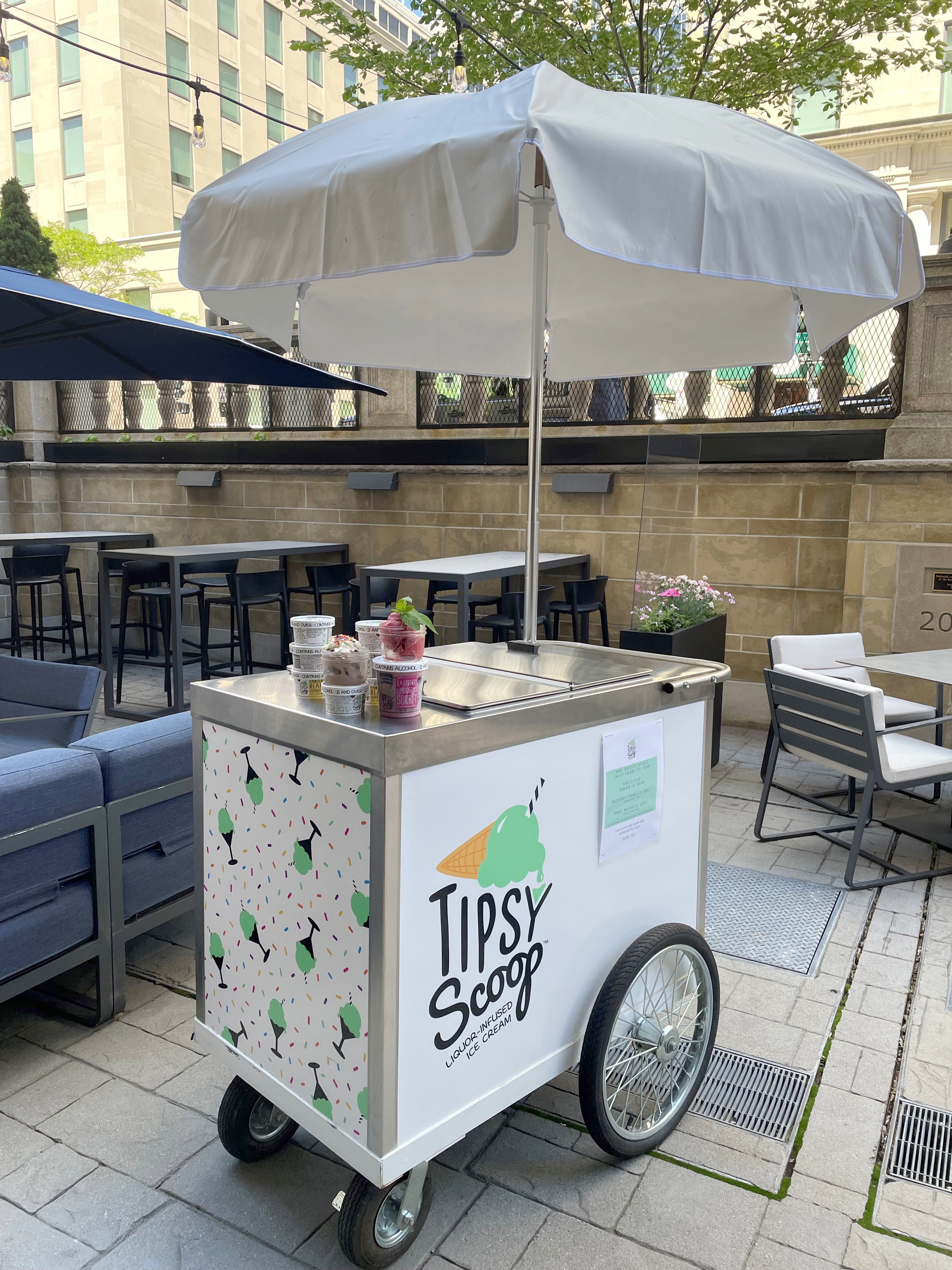 The Tipsy Scoop cart on the patio of the Precinct Kitchen + Bar at the Loews Boston Hotel is serving up flavors like dark chocolate whiskey salted caramel and vanilla bean bourbon through the end of summer.
