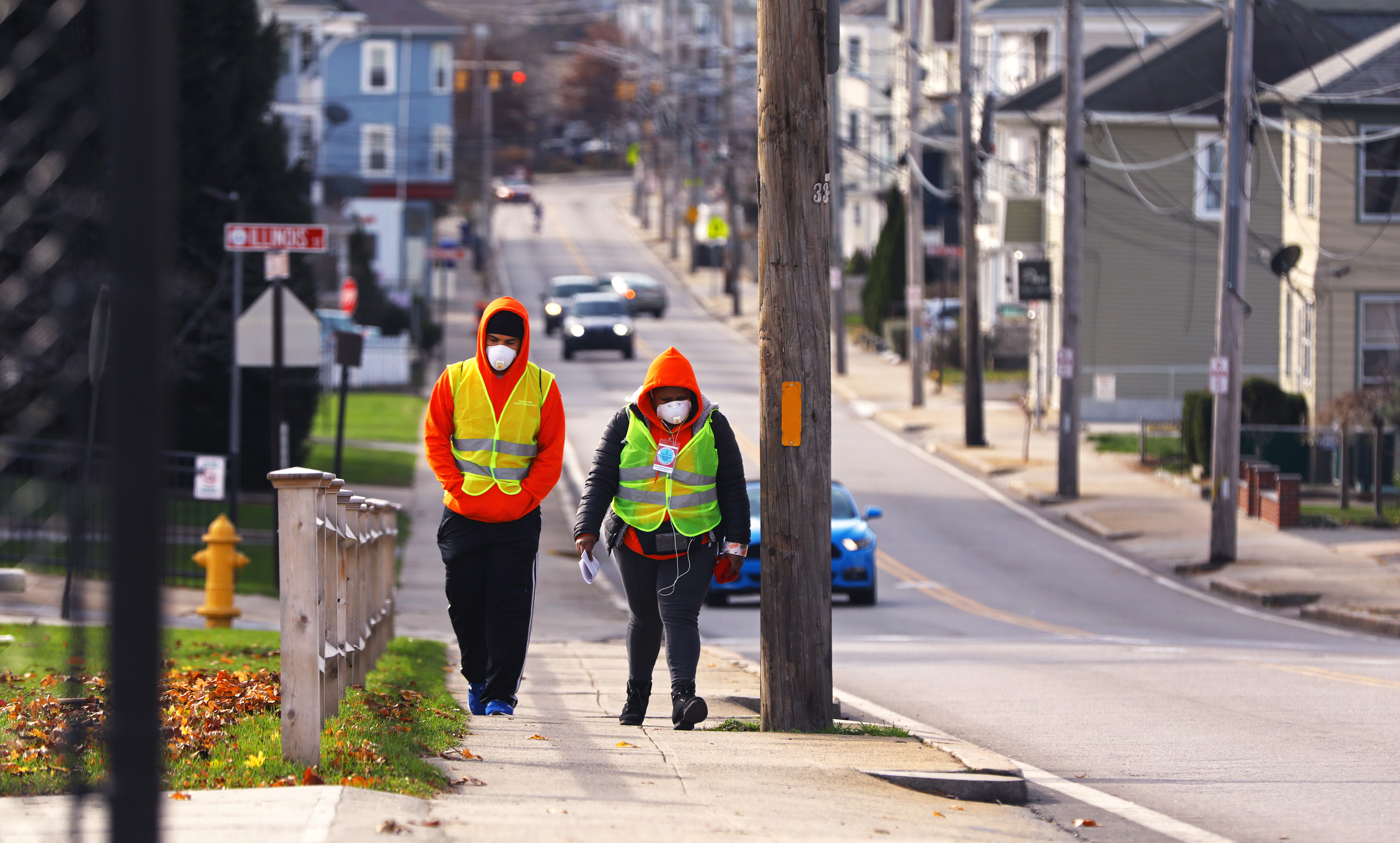 Central Falls health ambassadors Elvin Toro, left, and Yanina Zuniga walk around the city, passing out coronavirus information and face masks.