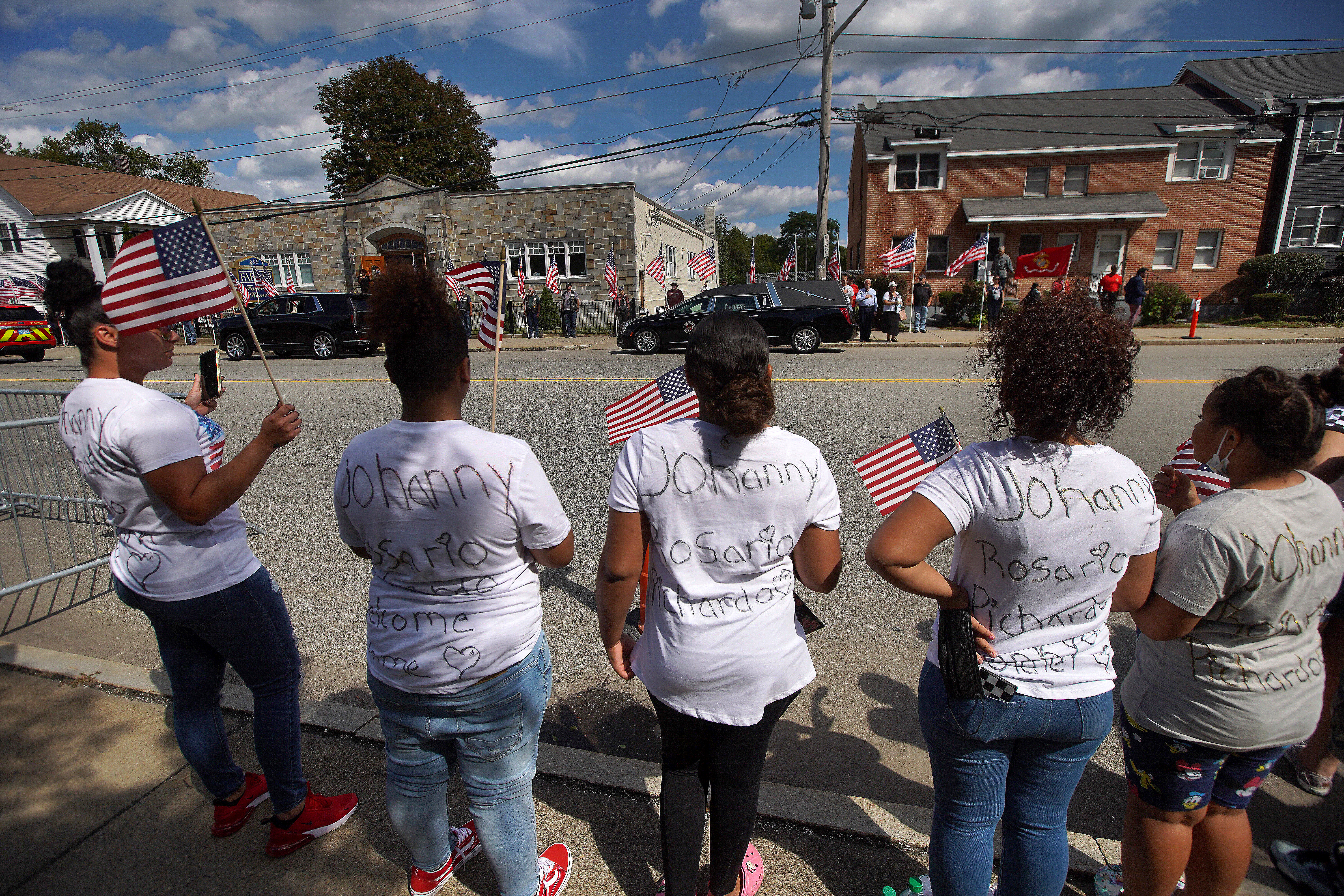 Maria Ogando, far left, of Worcester brought her two daughters and niece and nephew as members of the public lined the streets of Lawrence outside to welcome the procession bringing the remains of Sgt. Johanny Rosario Pichardo back to her hometown.