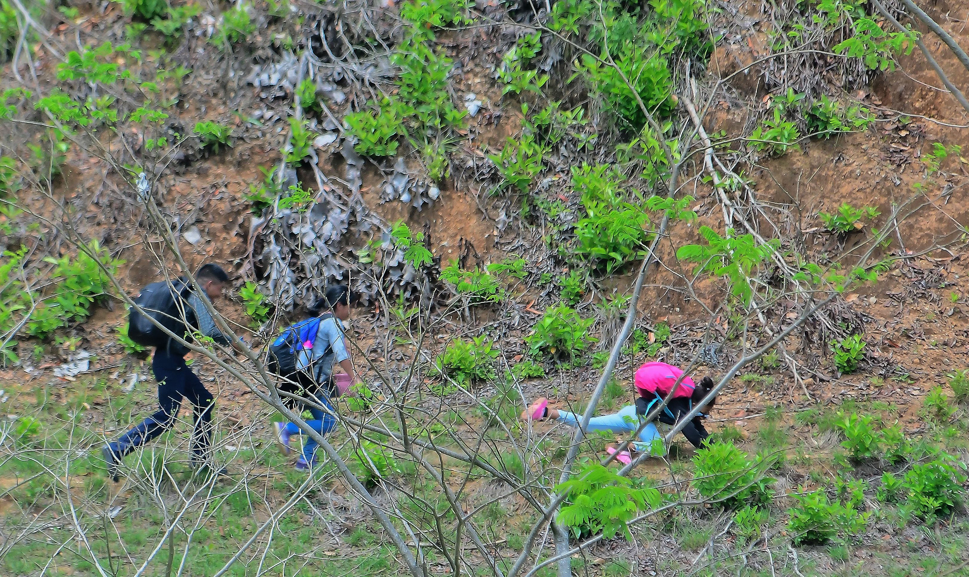 A migrant girl, heading for the US with others, tripped as they tried to illegally cross into Guatemala from Corinto, Honduras, on March 30.