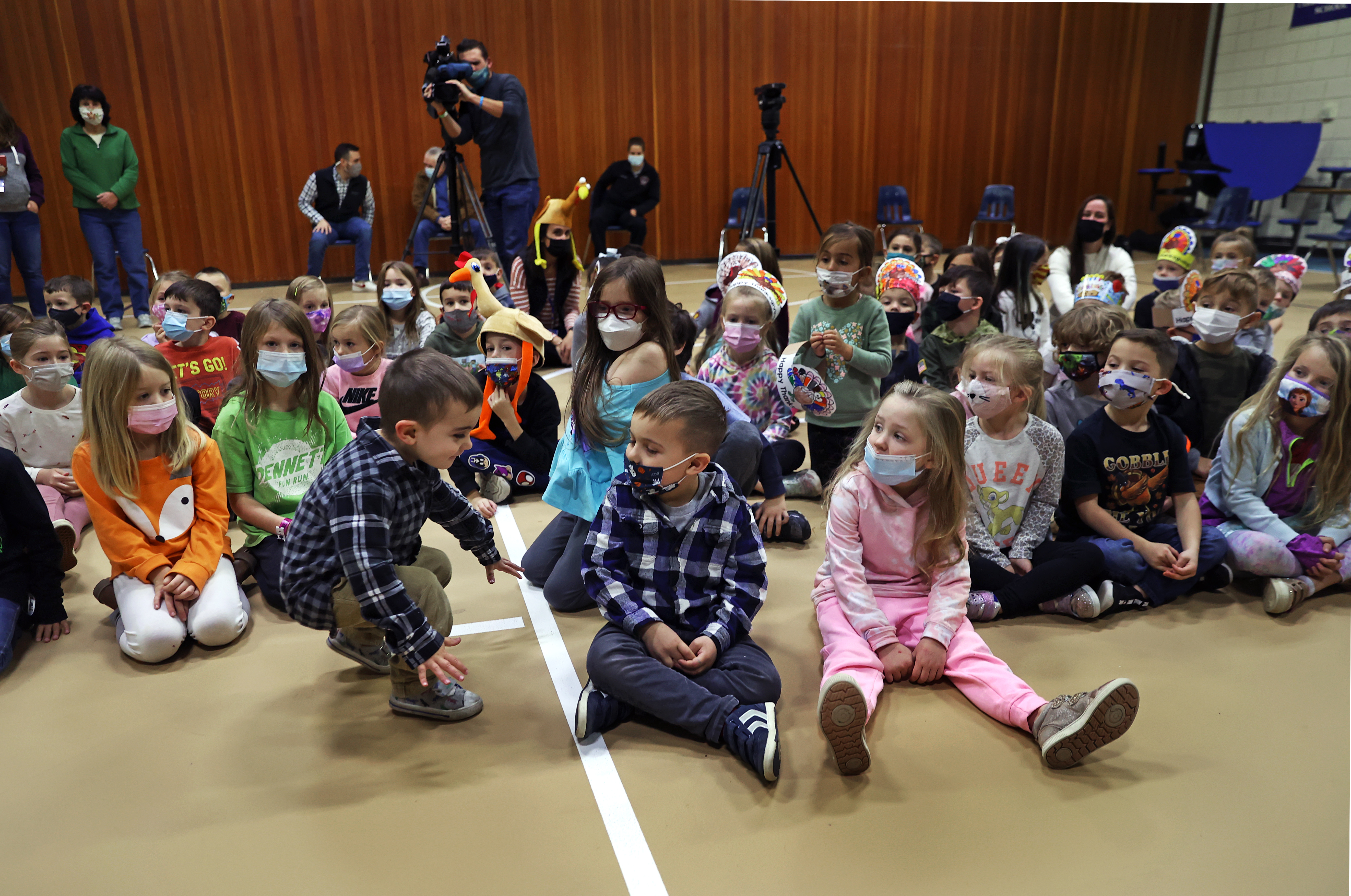 Five-year-old Cayden Galambos, center, is joined by his younger brother Blake and fellow classmates during the award ceremony.
