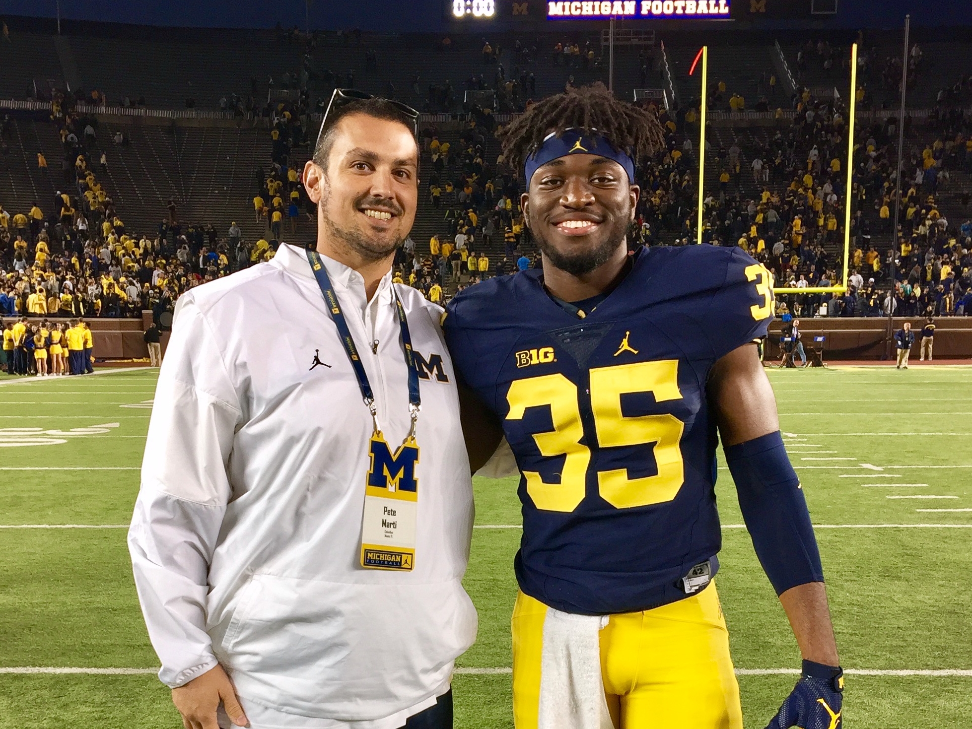 Uche with his high school defensive line coach Pedro Marti at Michigan Stadium.