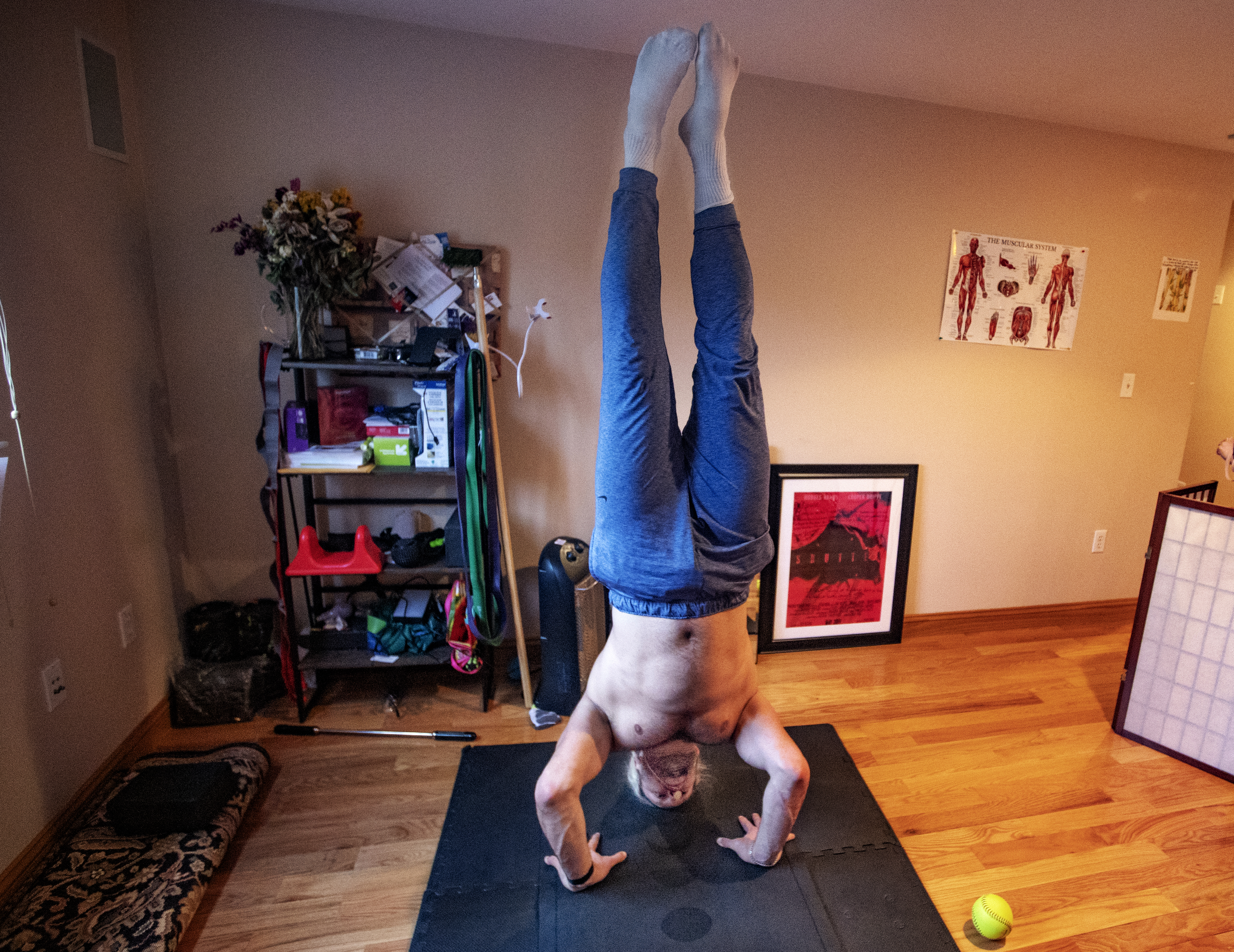 Chase Winovich does a hand stand in his home during a workout earlier this year.