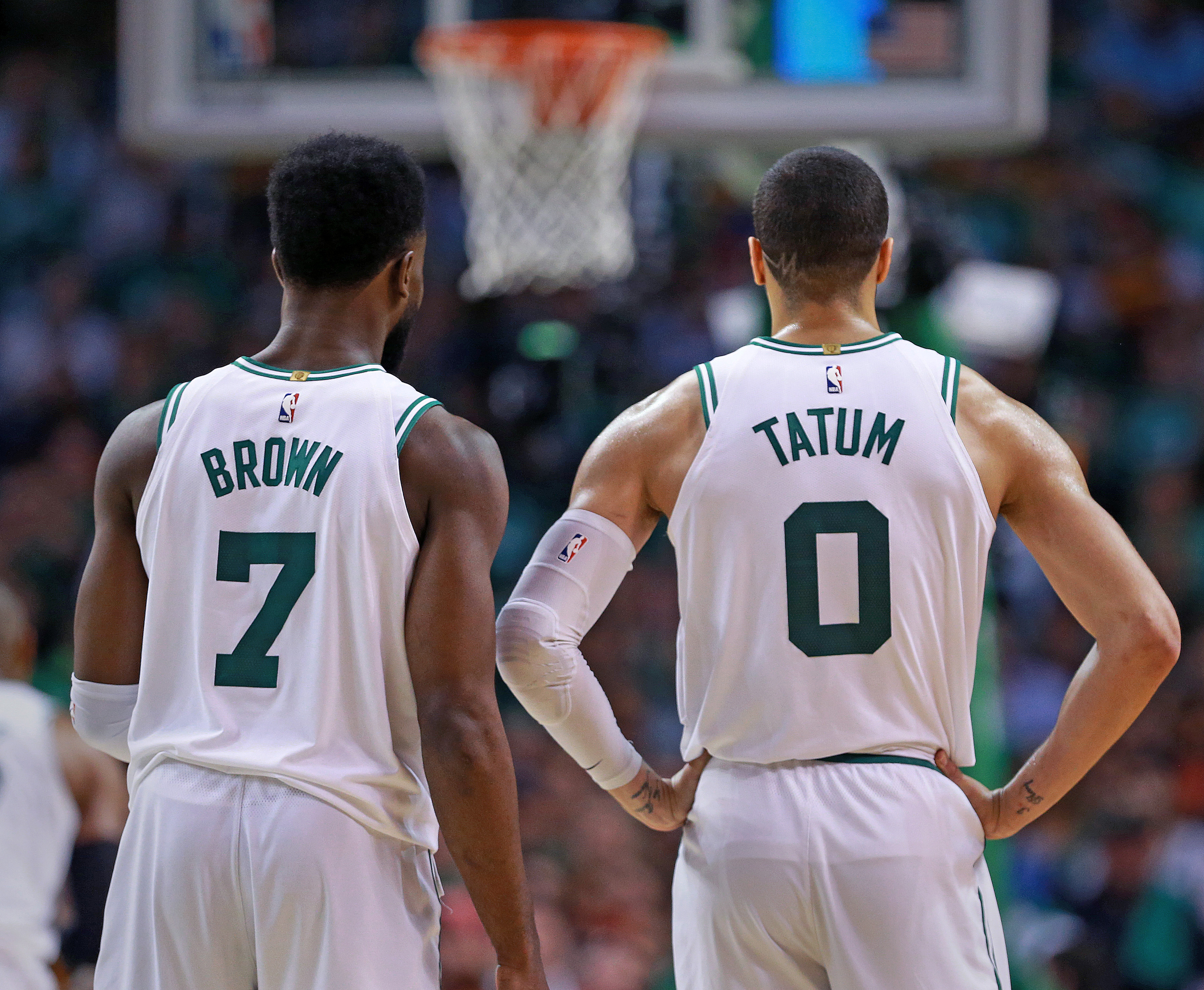 Jayson Tatum and Jaylen Brown watch a Boston Celtics teammate shoot free throws