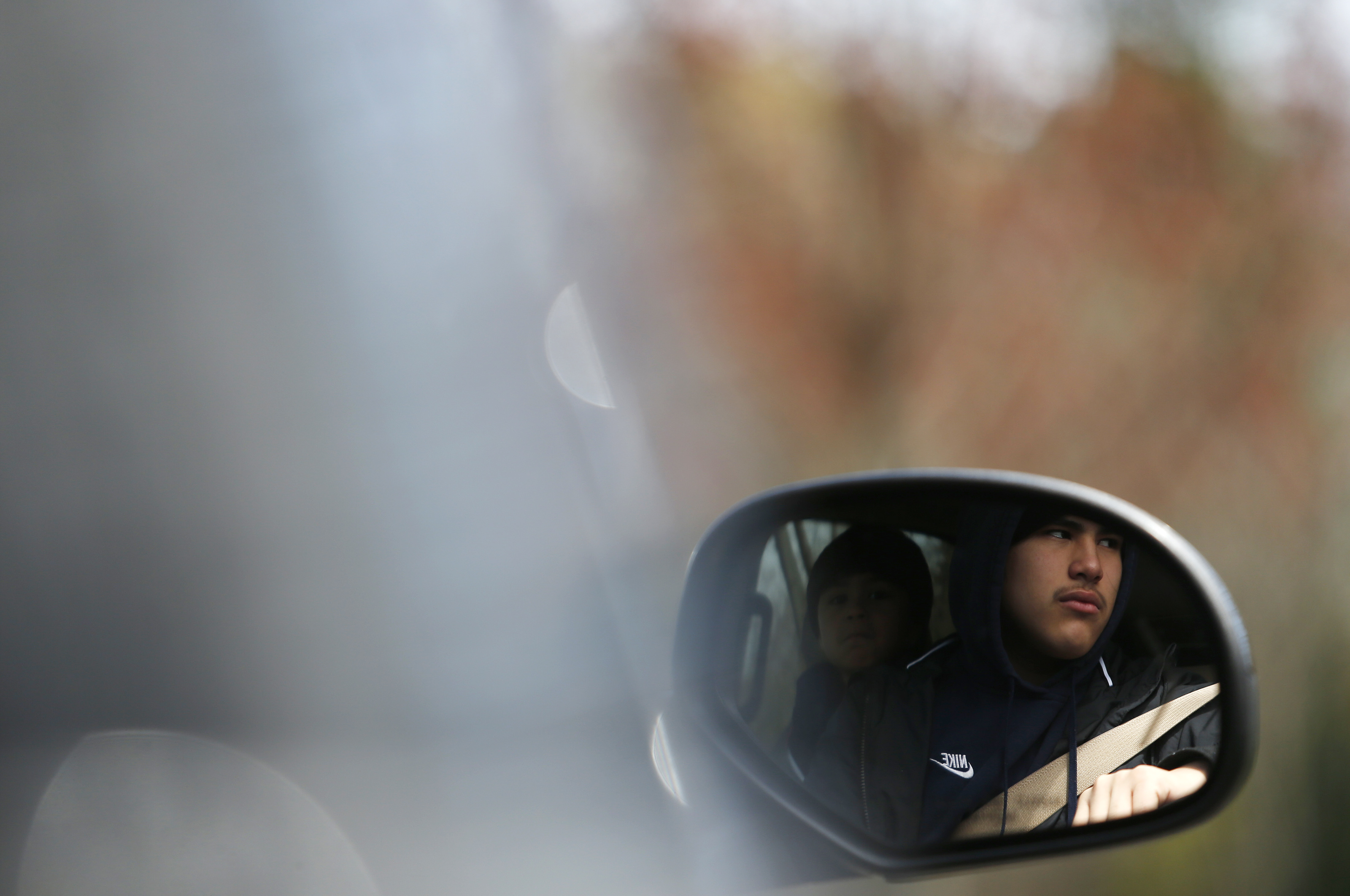 A mourner was reflected in the rearview mirror of his car as he attended Santos A. Rivas’s funeral.