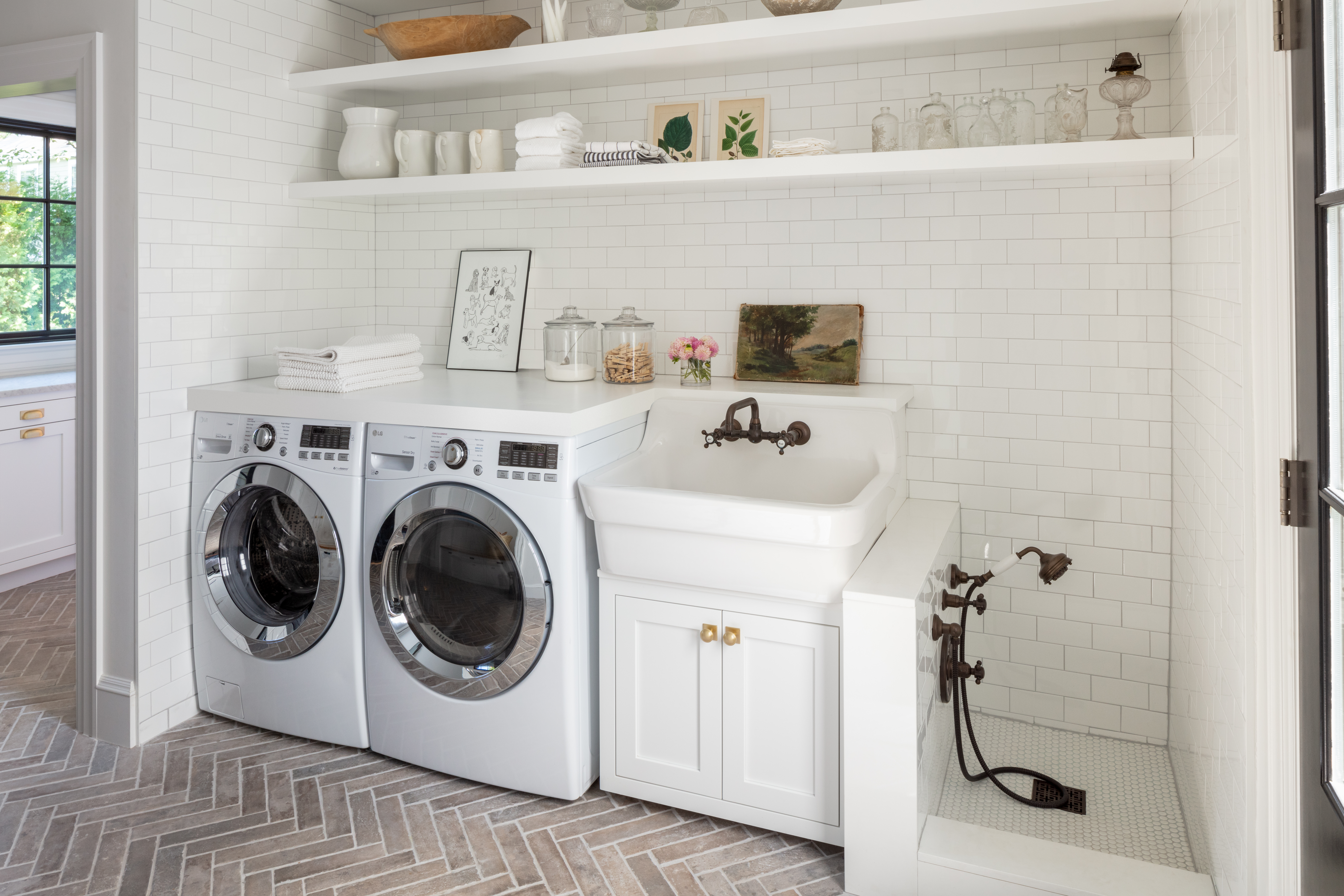 Traditional oil-rubbed bronze plumbing fixtures in the laundry area are a pointed departure from the sleek, unlacquered brass gooseneck
faucet in the kitchen.