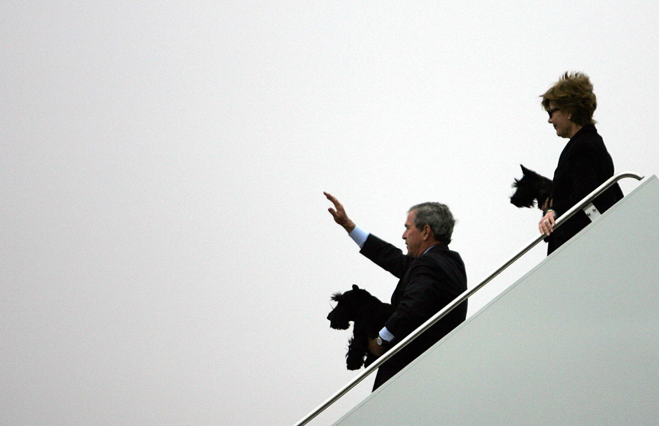 President George W. Bush carried dog Barney as his wife, Laura, carried Miss Beazley as they disembarked from Air Force One in 2005.