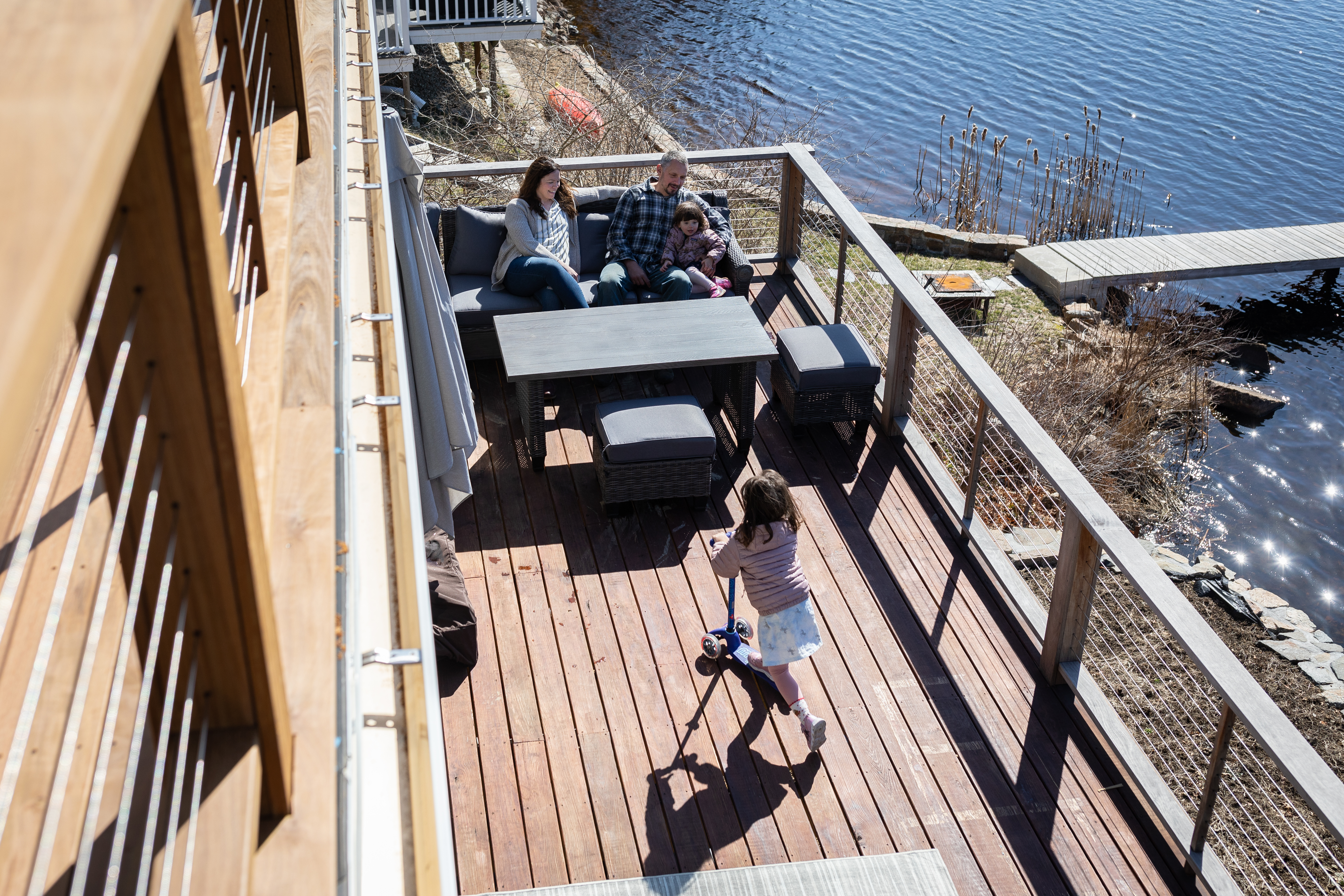 Mike and Emily Broderick watch as their 4-year-old daughter, Rowan, rides a scooter on a deck they built at their home in Essex.