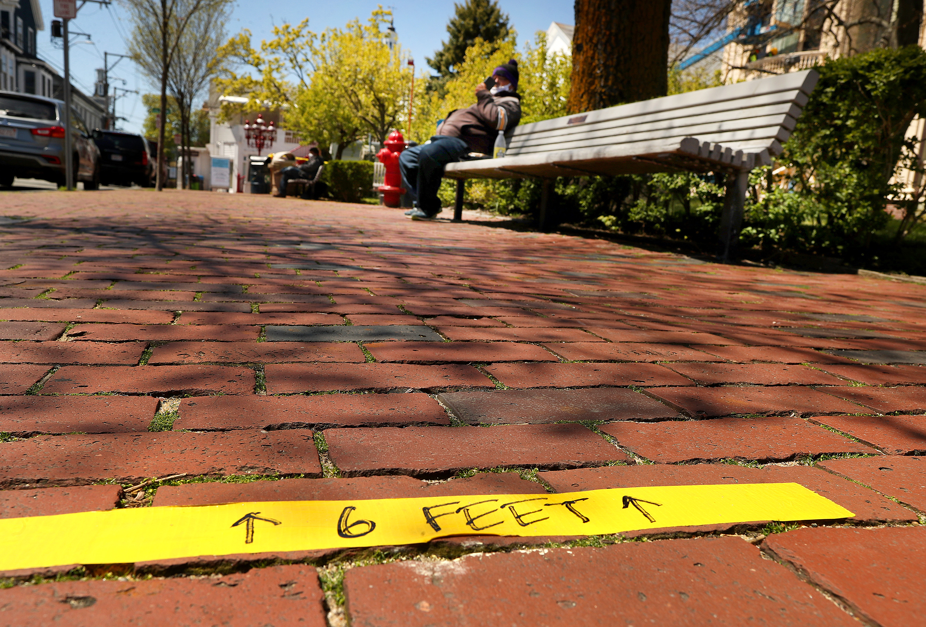 Tape on a sidewalk on Commercial Street reminds visitors of social distancing precautions.