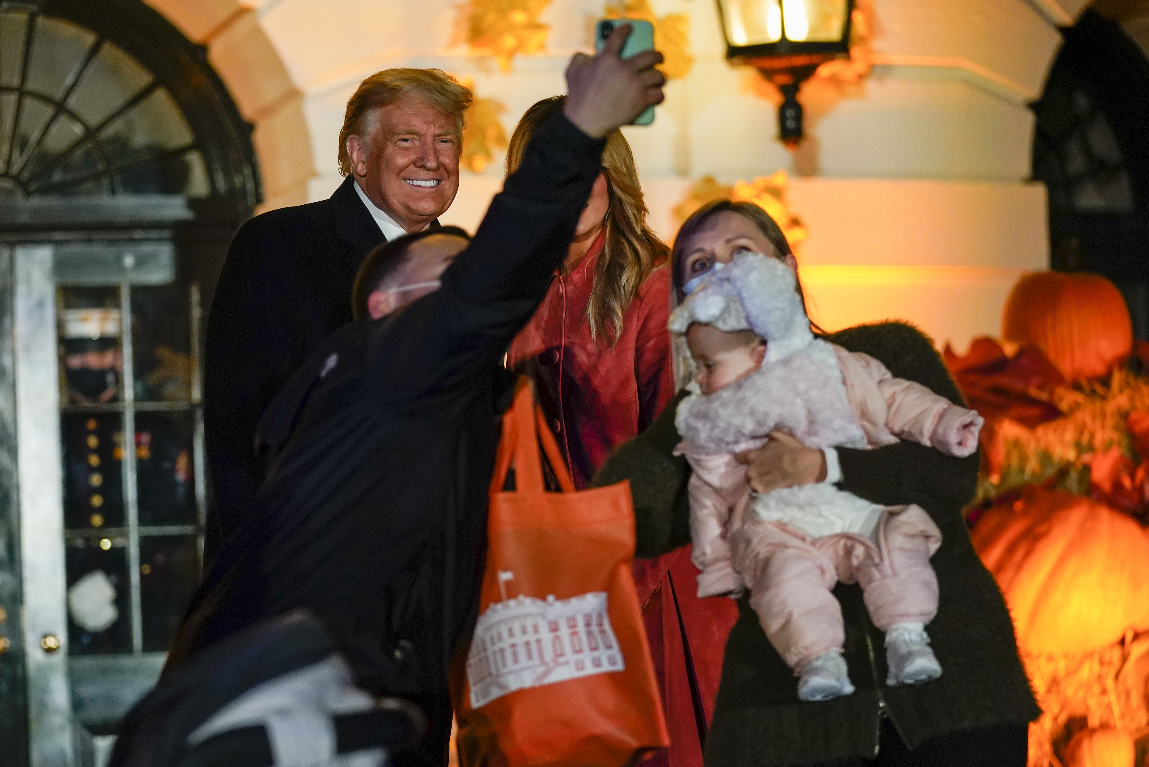 President Donald Trump and first lady Melania Trump greet trick-or-treaters on the South Lawn during a Halloween celebration at the White House, Sunday, Oct. 25, 2020 in Washington.