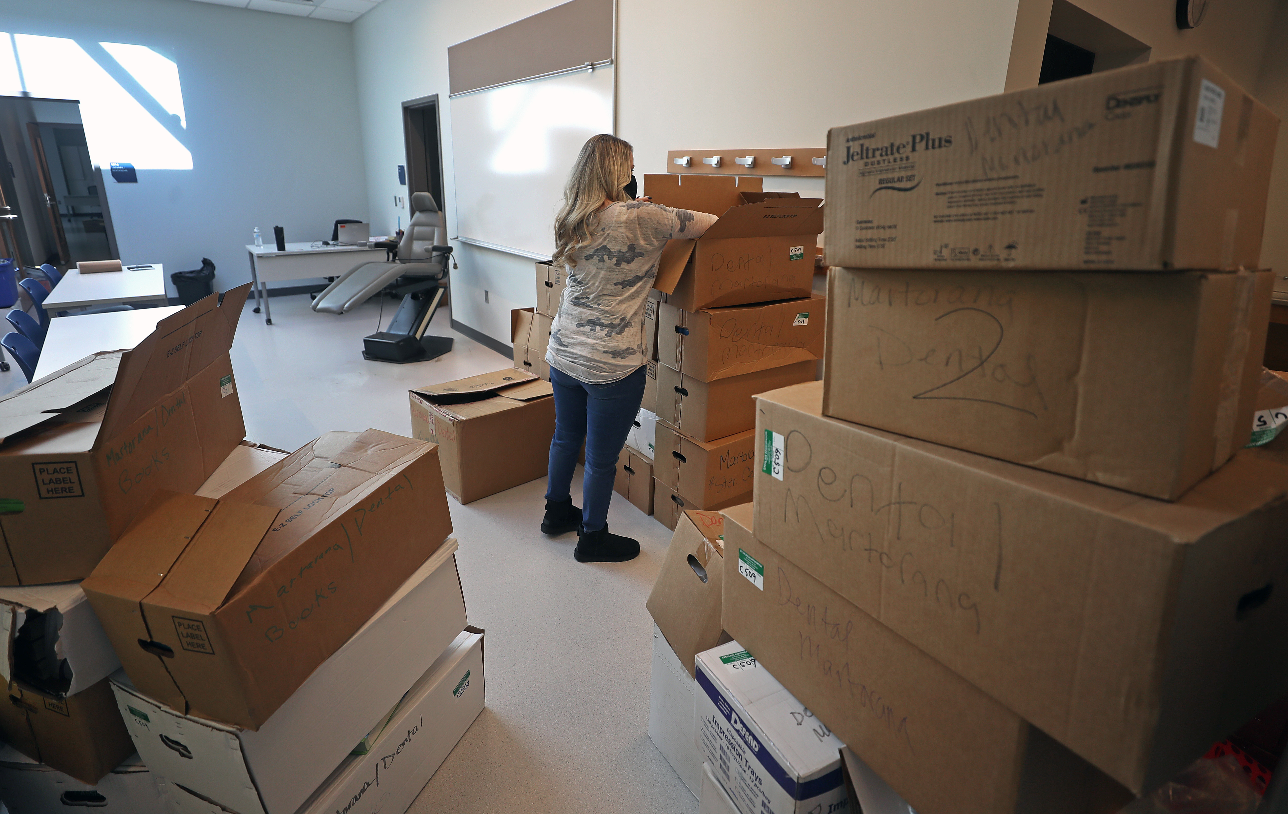 Tammy Martorana unpacks boxes in the dental assistant classroom at Somerville's new high school.