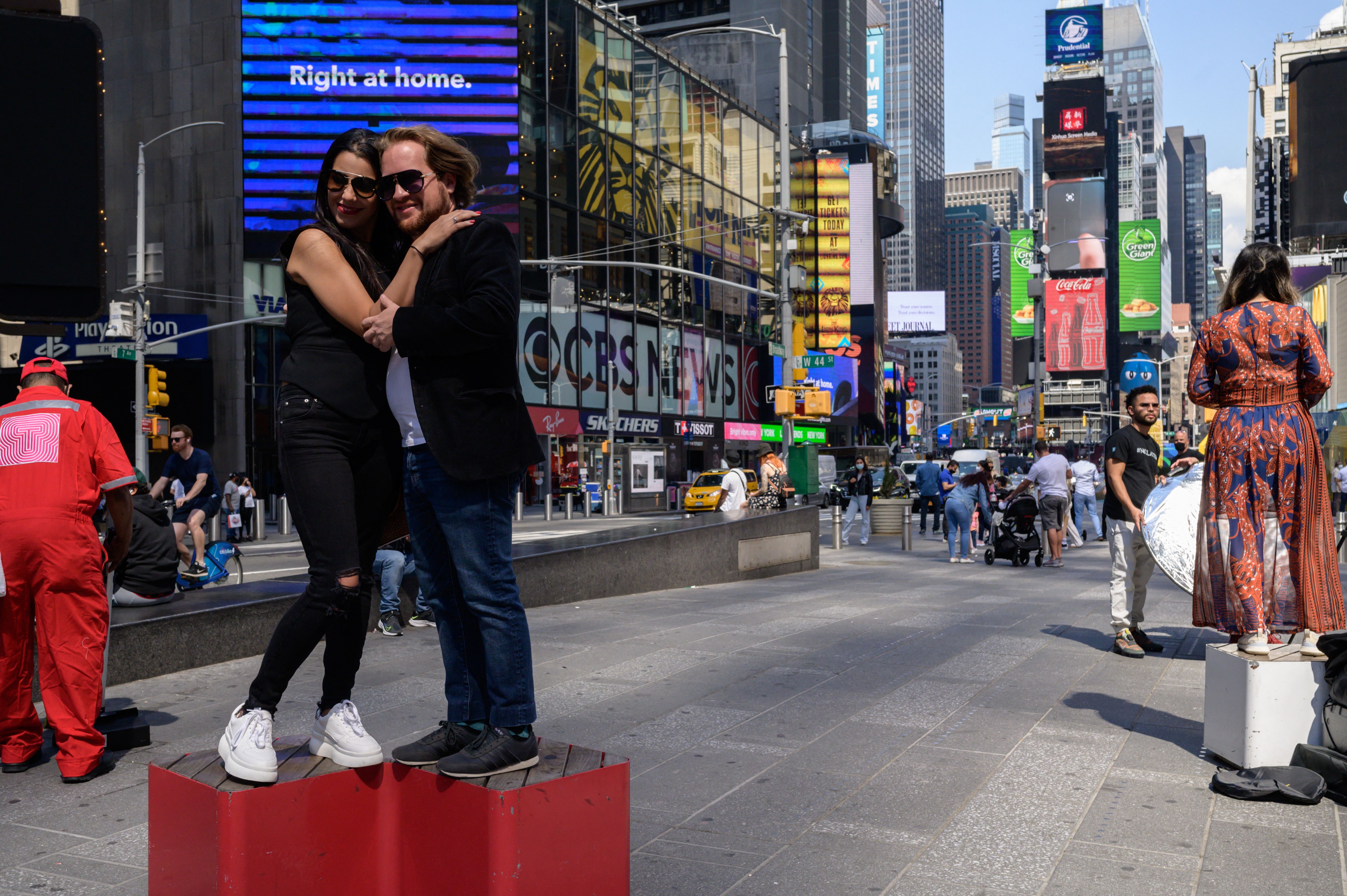 A couple pose for photos in Times Square on May 17, 2021.