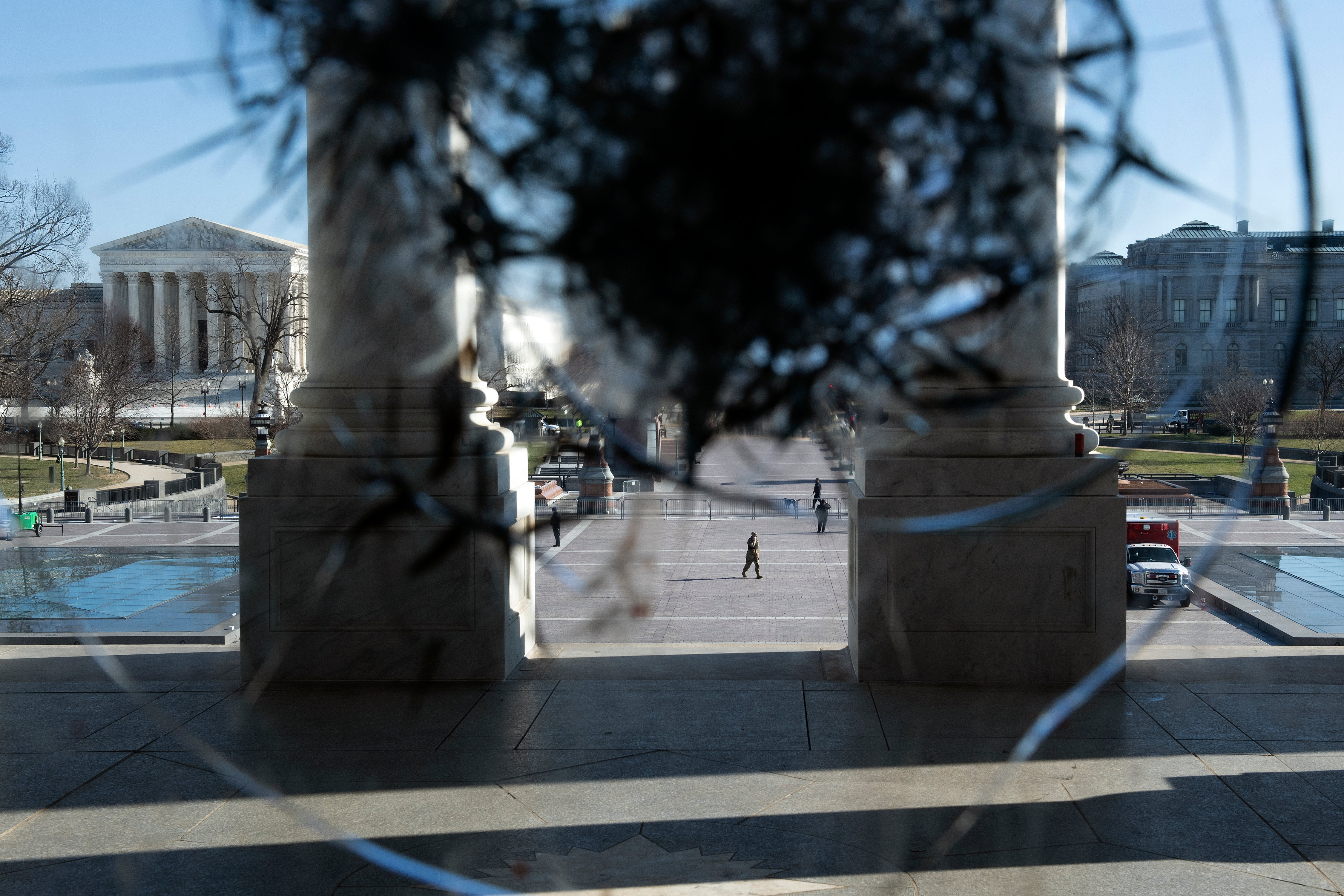 The Supreme Court seen through a broken window a day after a pro-Trump mob broke into the Capitol.