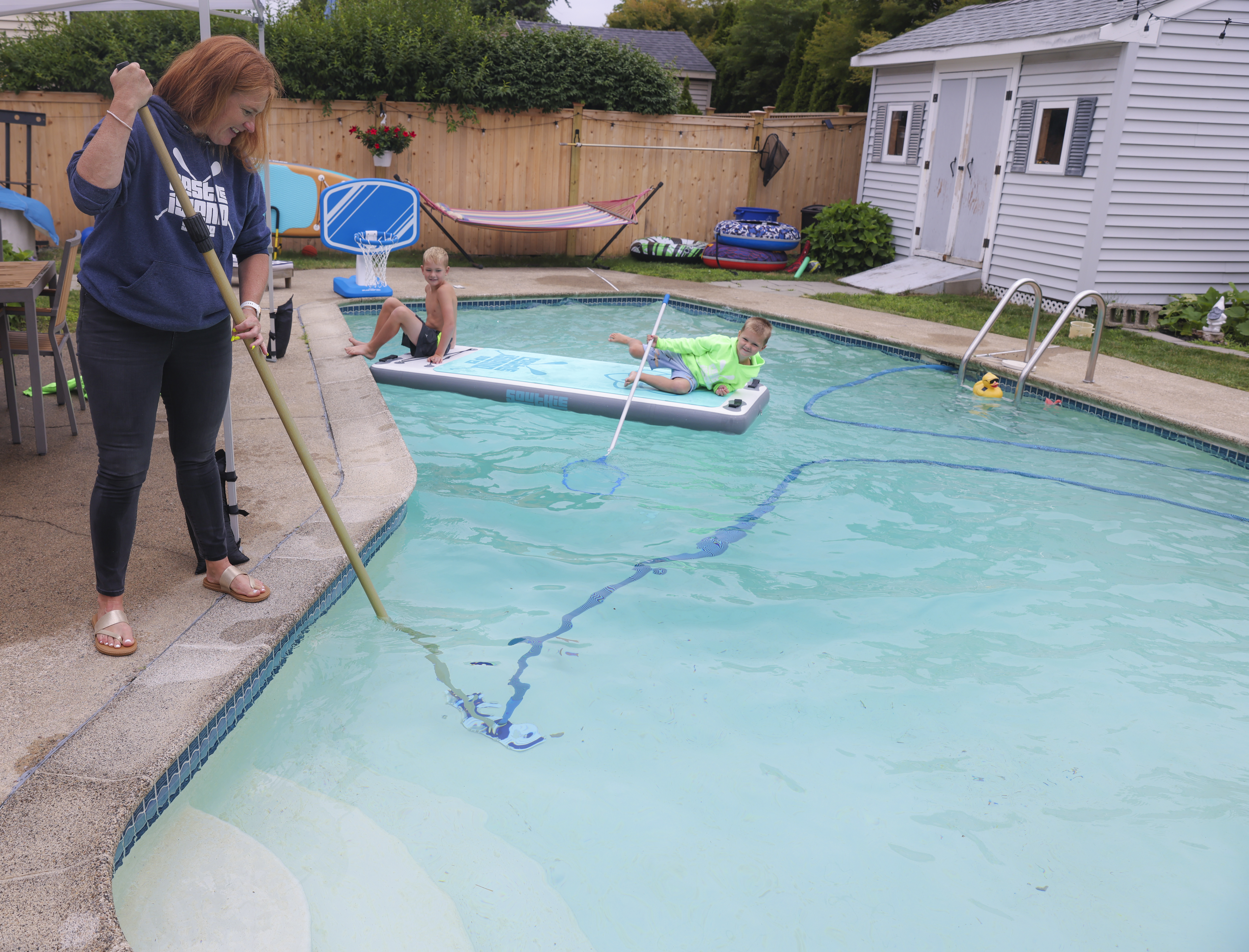 Erin Moriarty, with the help of her sons, Danny, 8, and Billy, 5, cleaned her backyard pool.