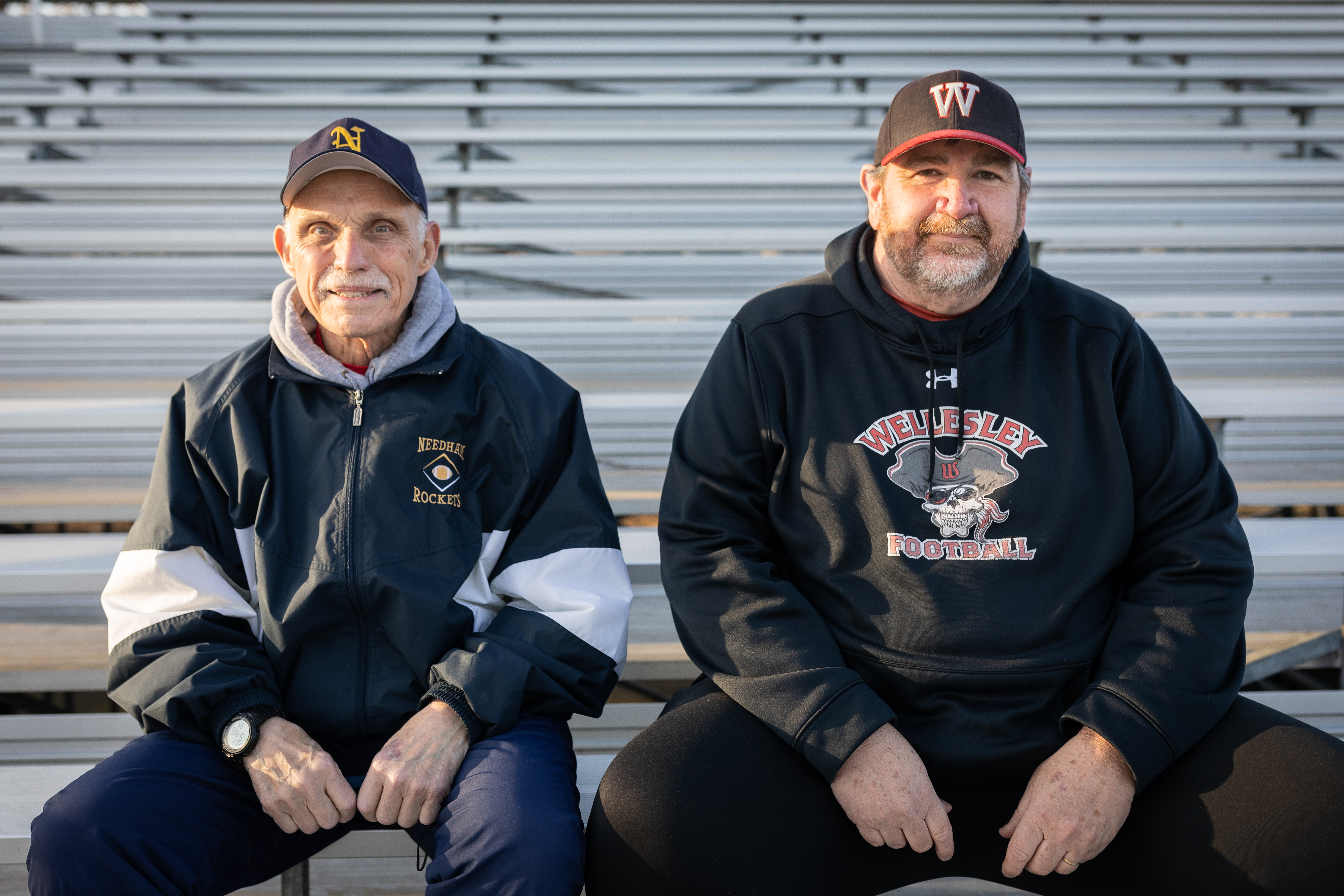 “When we play at Needham, there is nothing like the sight of that hill full of people and I’m sure a large element of that will be missing, but we’re really all about what’s going on between the lines," said former head coach Bill Tracey (right), seated alongside former Needham head coach Roy Johan.