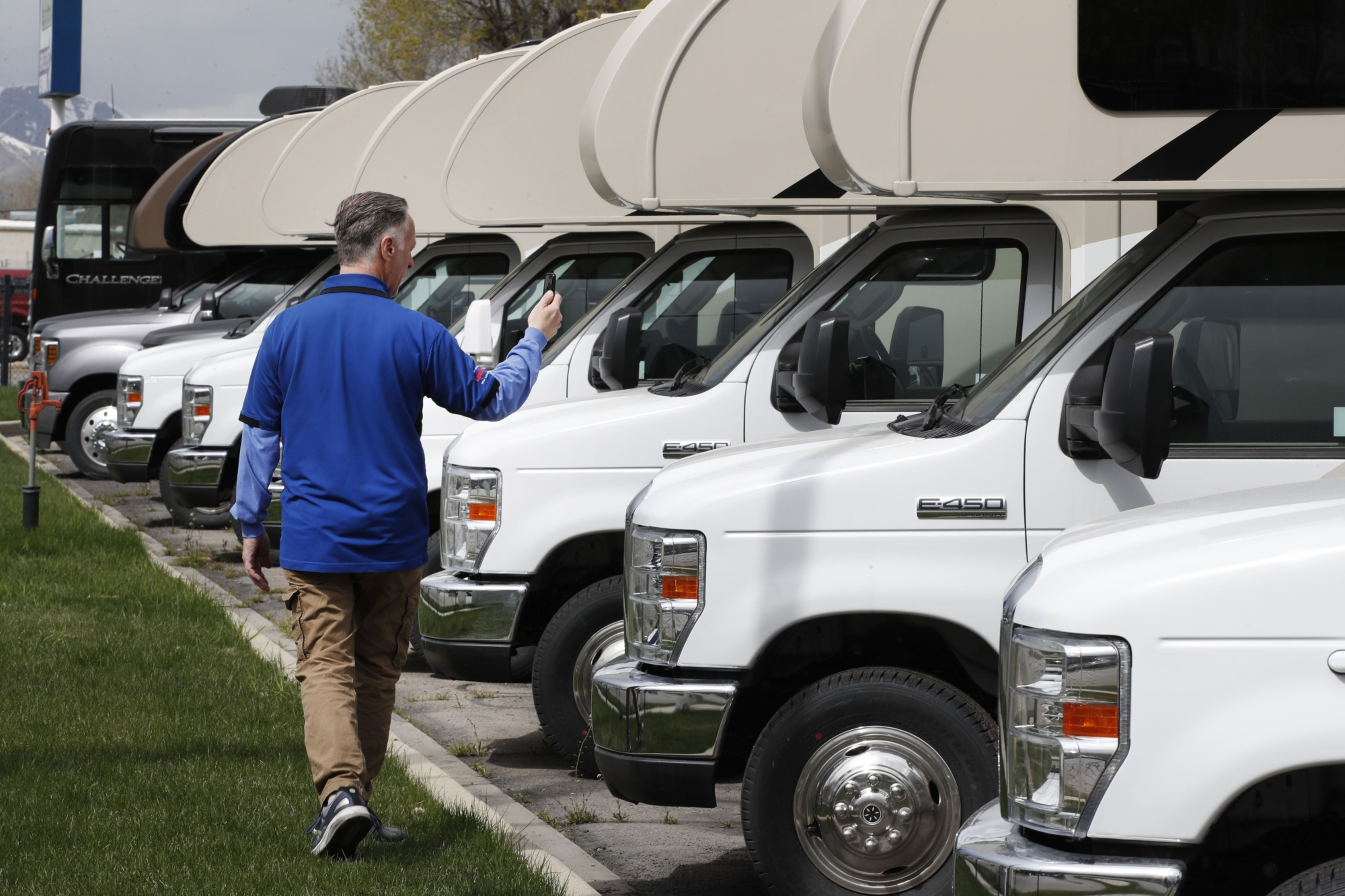 A salesperson shows potential customers RVs virtually, using his mobile phone, at the Motor Sportsland RV dealership in Salt Lake City.