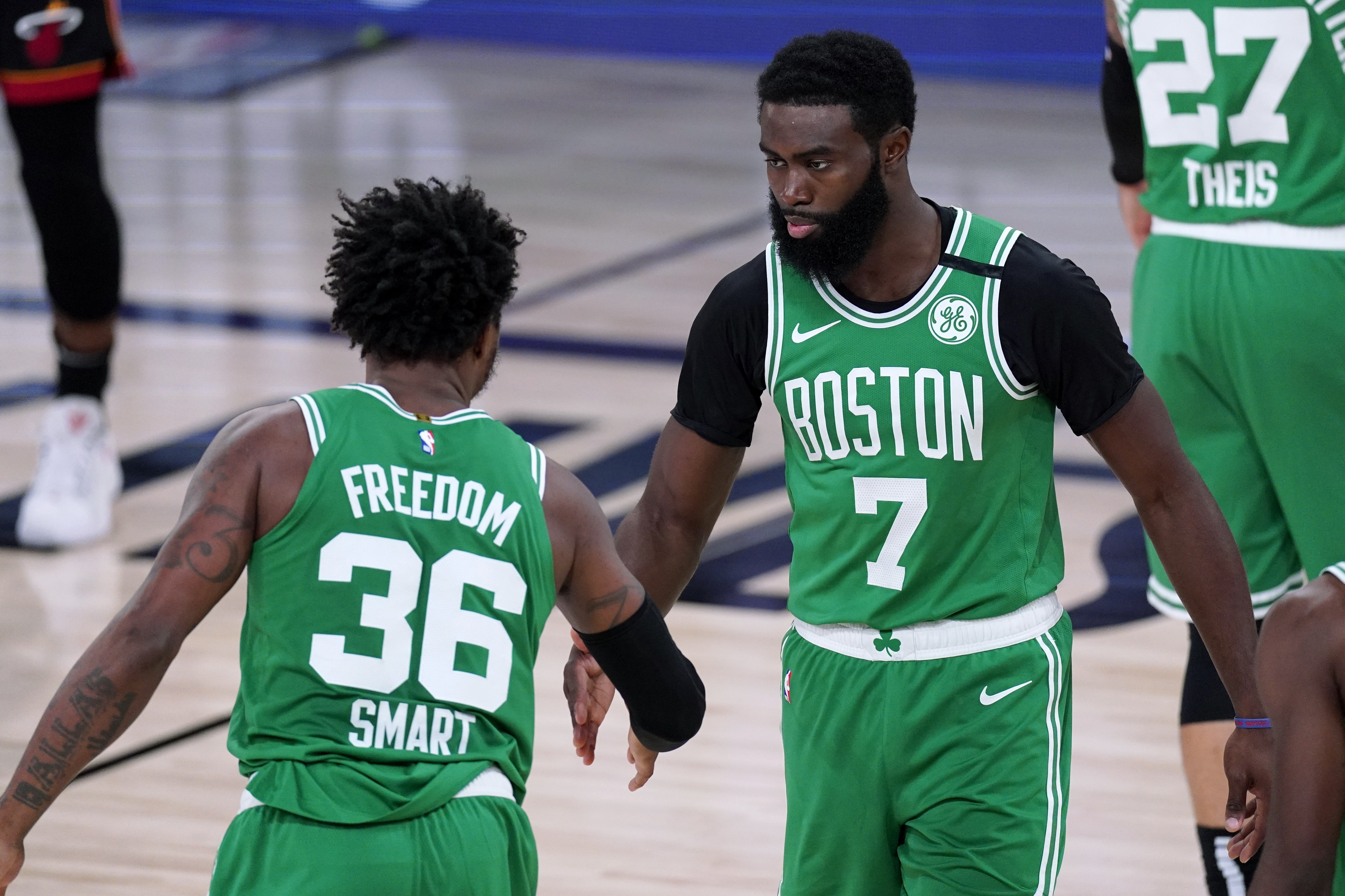 Marcus Smart and Jaylen Brown greet each other on the court during the first half of Saturday's game.
