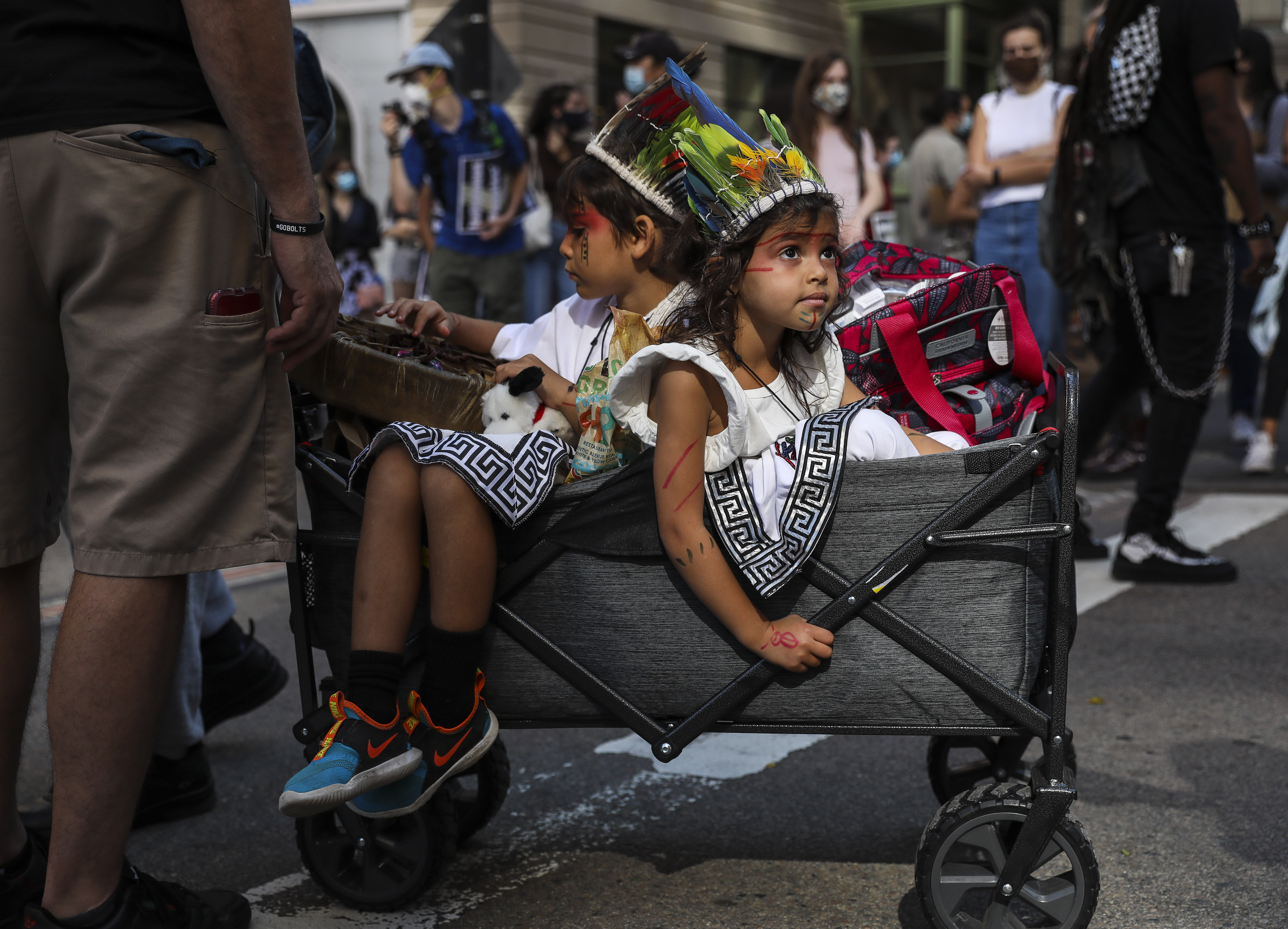 Zamir Nieves, 6, sits in a cart with his younger sister Aminah, 4, while they participate in the Indigenous Peoples Day rally and march on Saturday afternoon.