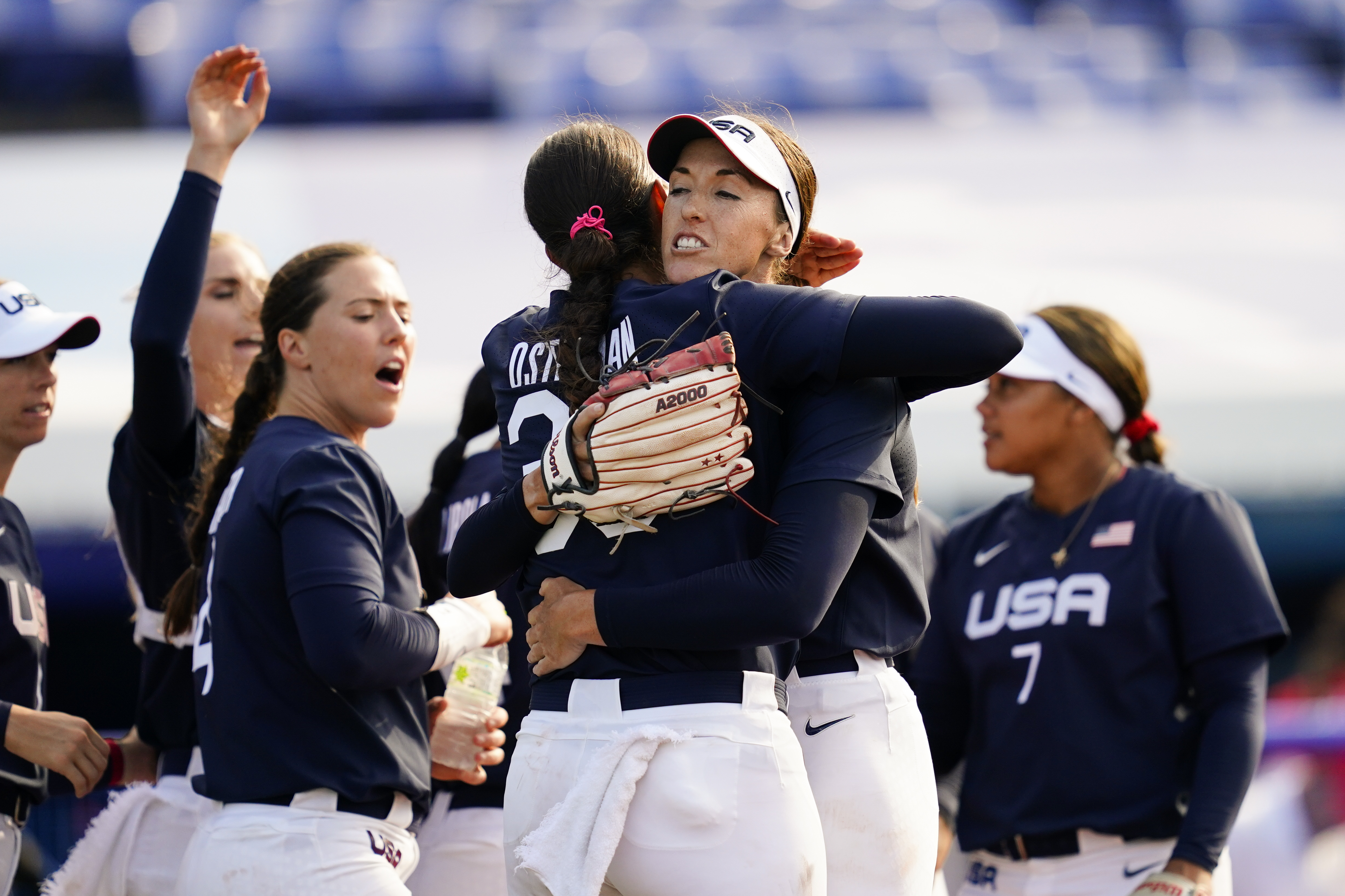 Monica Abbott (center right) and Cat Osterman embrace after defeating Mexico on Saturday.